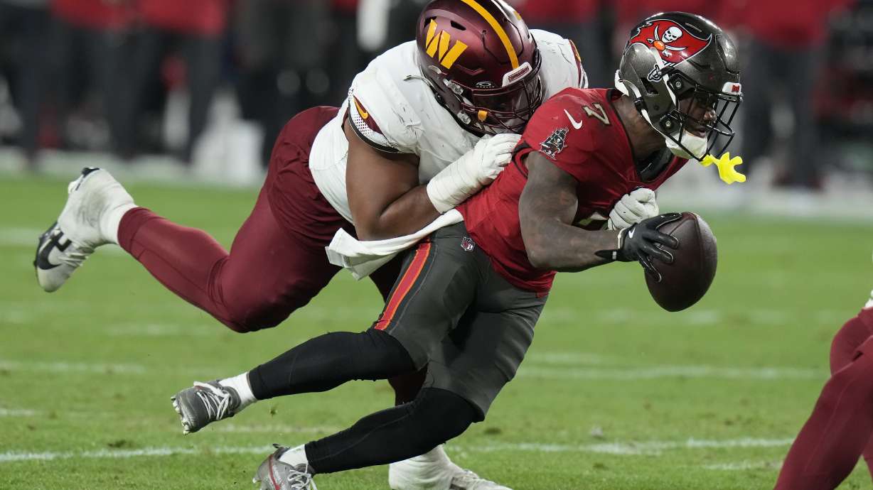 FILE- Tampa Bay Buccaneers running back Bucky Irving, right, runs against Washington Commanders defensive tackle Jonathan Allen during the second half of an NFL wild-card playoff football game in Tampa, Fla., Jan. 12, 2025.