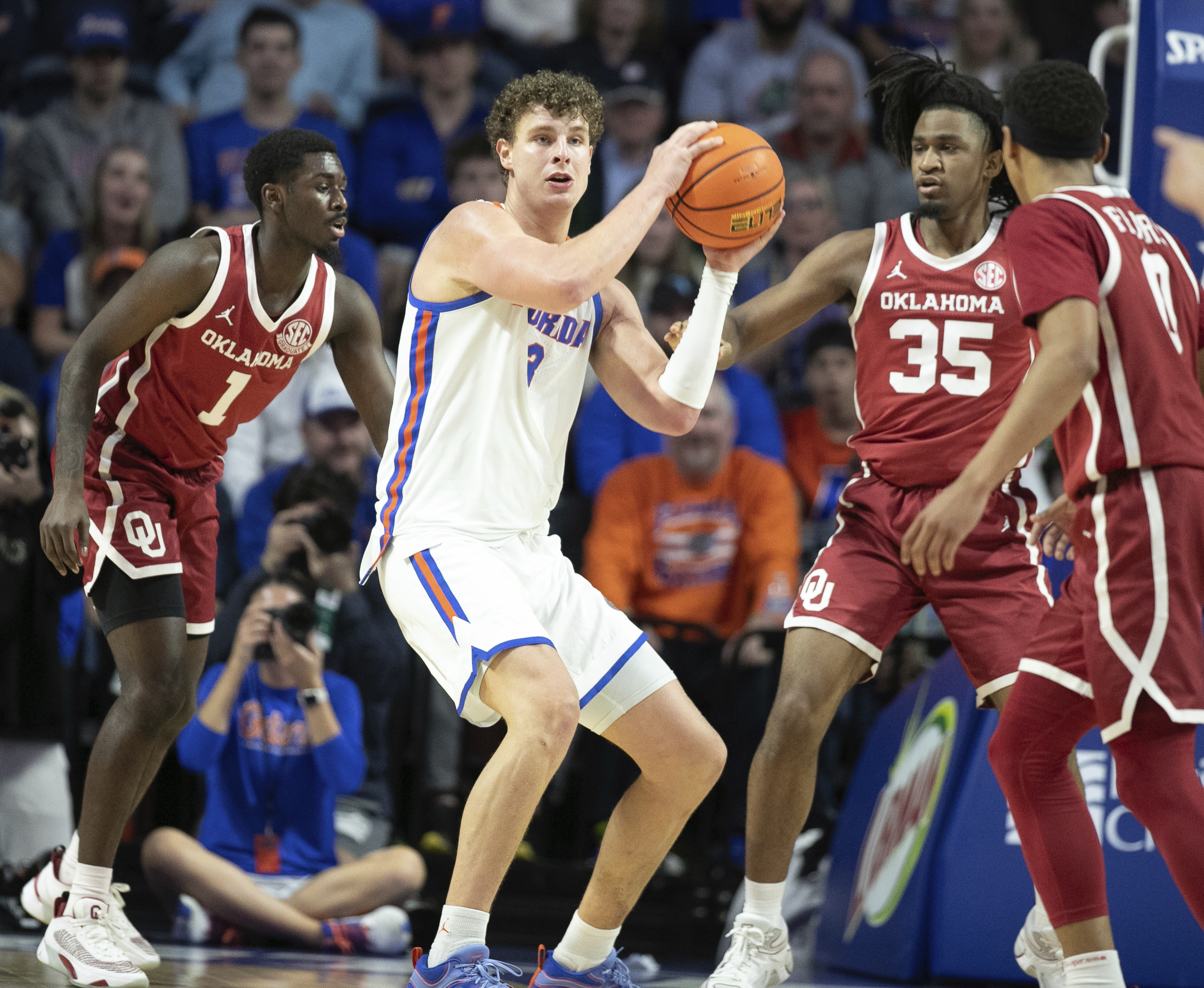 Florida center Micah Handlogten passes under pressure from Oklahoma forward Glenn Taylor Jr. (35) during the first half of an NCAA college basketball game, Tuesday, Feb. 18, 2025, in Gainesville, Fla. 