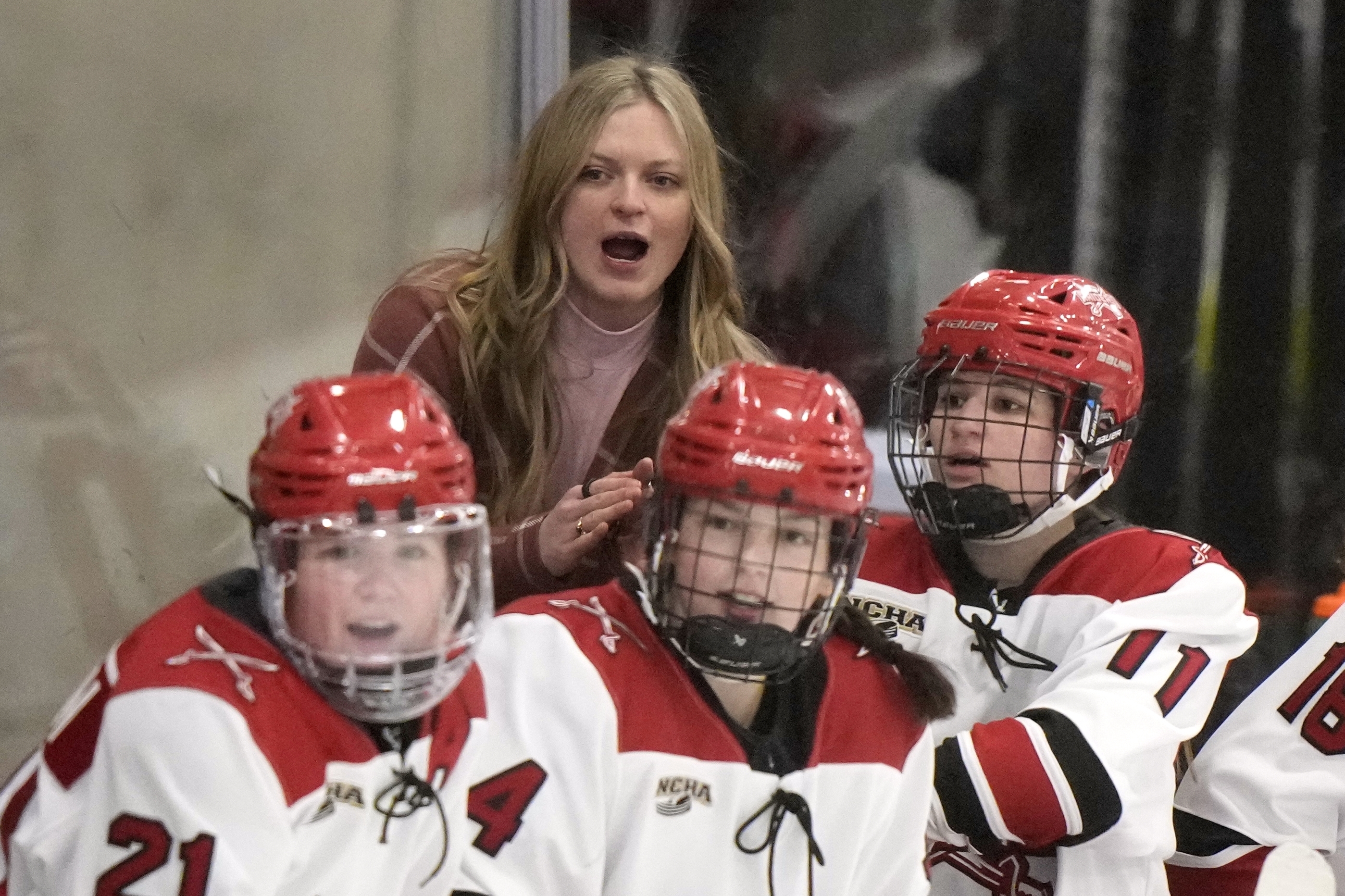 Milwaukee School of Engineering head coach Baylee Marabella, top, cheers during a women's Division III NCAA college hockey game against Wake Forest College, Friday, Feb. 14, 2025, in Milwaukee.