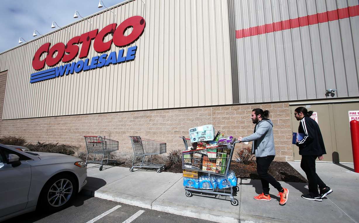 Jared Camberos and Jordi Camberos take water, toilet tissue and other items to their car as they and other shoppers at the Lehi Costco prepare themselves over coronavirus concerns on Tuesday, March 3, 2020. Shoppers are being told that they can only buy up to five cases of water and up to three cases of toilet tissue from that store.