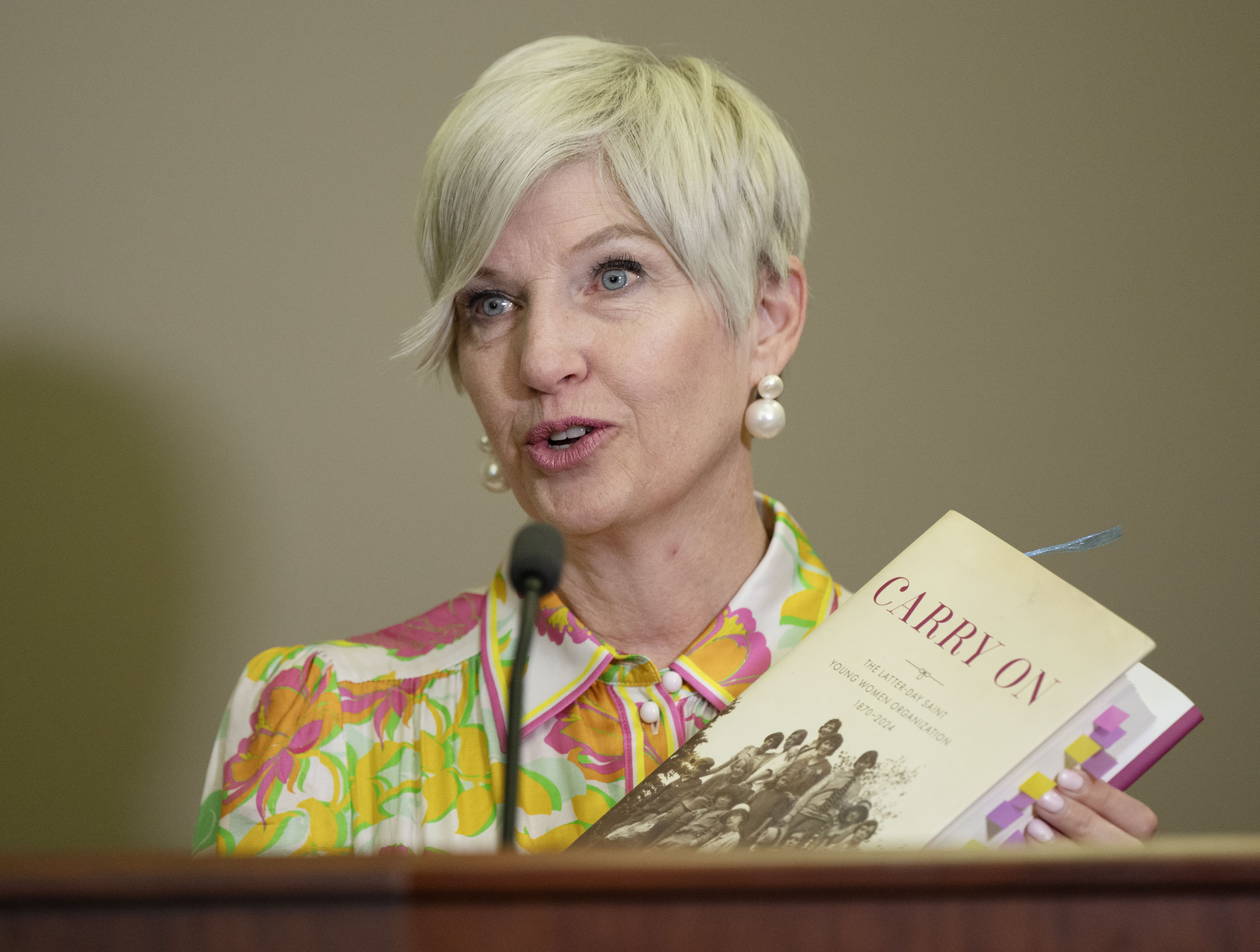 Young Women General President Emily Belle Freeman holds a copy of "Carry On," a new history of the Young Women program at a press conference in Salt Lake City on Tuesday.