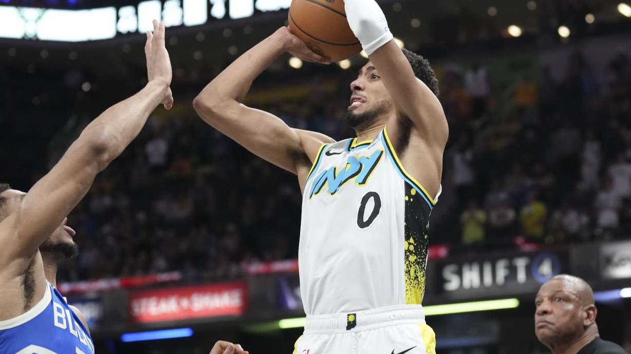 Indiana Pacers guard Tyrese Haliburton (0) shoots a three-point shot over Milwaukee Bucks forward Giannis Antetokounmpo (34) to tie the game late in the second half of an NBA basketball game in Indianapolis, Tuesday, March 11, 2025.