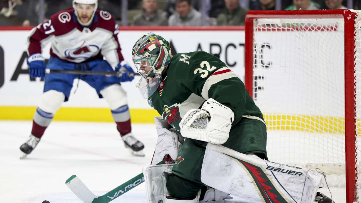 Minnesota Wild goaltender Filip Gustavsson (32) saves the puck while Colorado Avalanche left wing Jonathan Drouin, left, looks on during the second period of an NHL hockey game, Tuesday, March 11, 2025, in St. Paul, Minn.