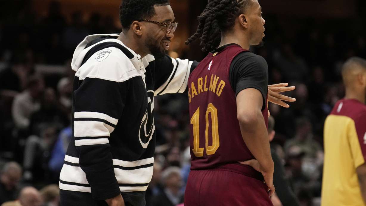 Cleveland Cavaliers guard Donovan Mitchell, left, who did not dress for the game, talks with teammate Darius Garland (10) in the second half of an NBA basketball game against the Brooklyn Nets, Tuesday, March 11, 2025, in Cleveland.