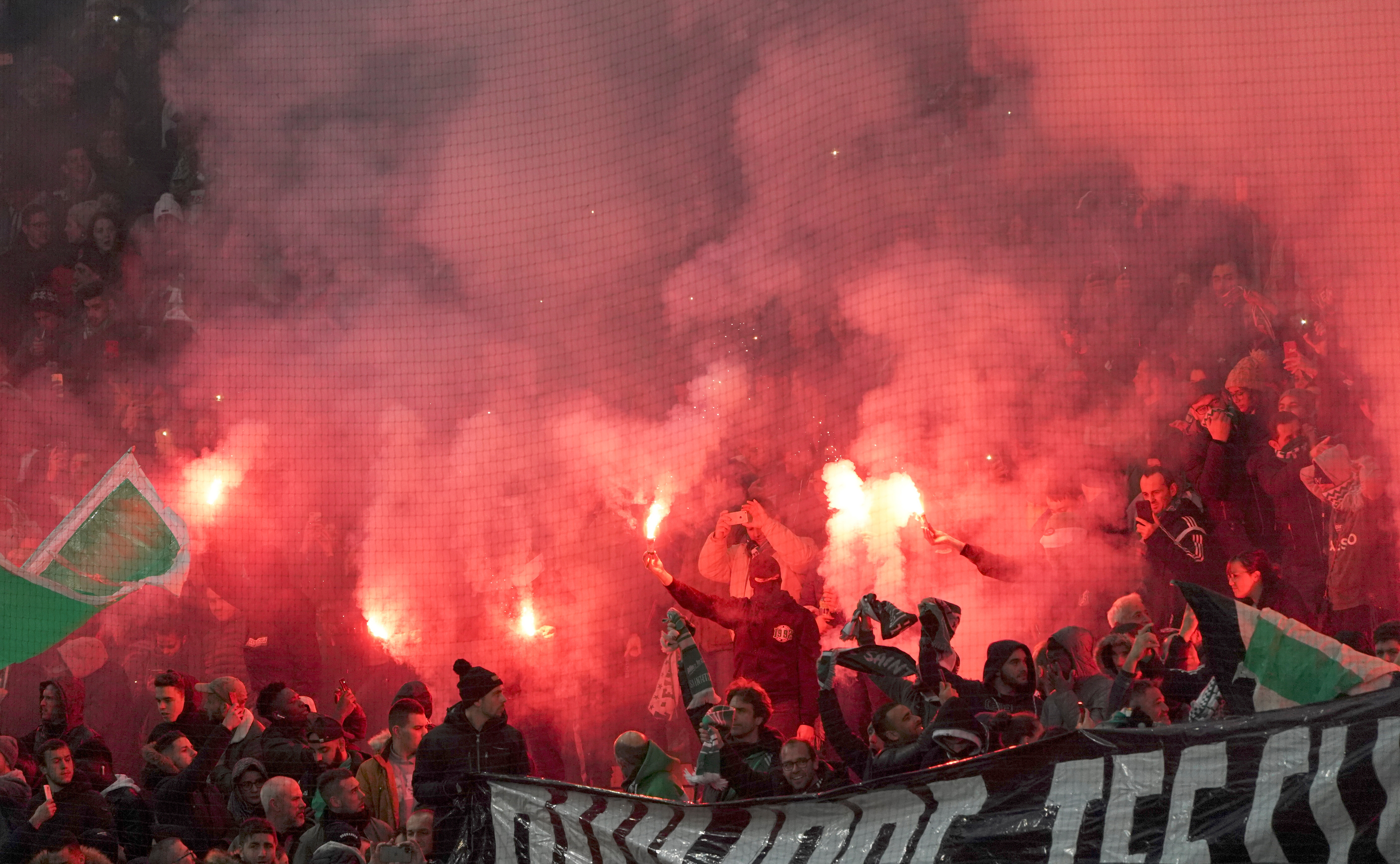 FILE - Saint-Etienne's fans light flares before the French League One soccer match between Saint-Etienne and Paris Saint-Germain, at the Geoffroy Guichard stadium, in Saint-Etienne, central France, on Dec. 15, 2019. 