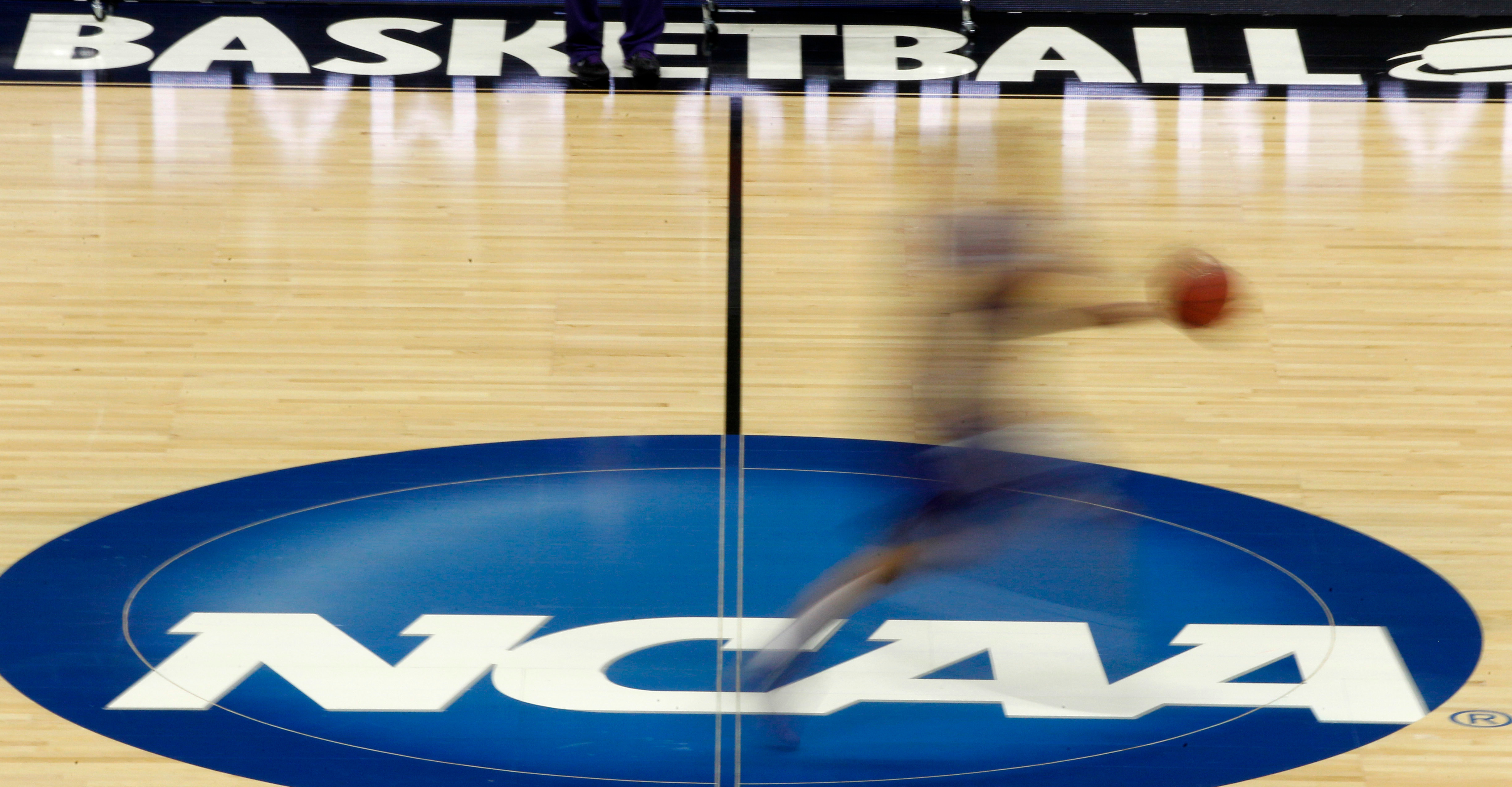 FILE - In this March 14, 2012, file photo, a player runs across the logo during NCAA college basketball practice in Pittsburgh. 