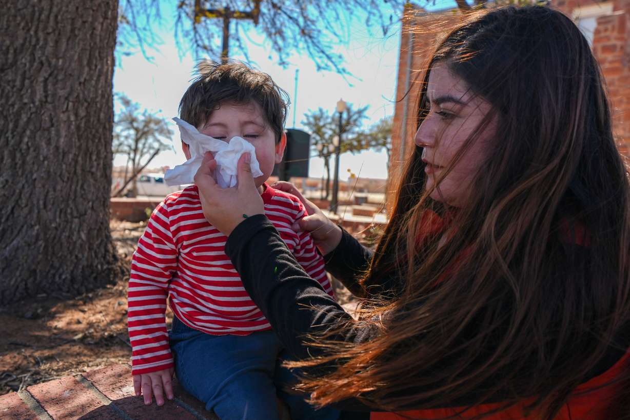 Jennifer Sanchez wipes the face of her son Saul Escamilla, 1, after she got vaccine appointments for her children at the Ector County Health Department Feb. 24 in Odessa, Texas.