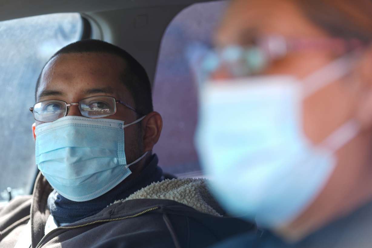 Fernando Tarin, left, of Seagraves, Texas, and his mother Josie Granado wear face masks after being tested for measles at a mobile testing site outside Seminole Hospital District Feb. 21 in Seminole, Texas.