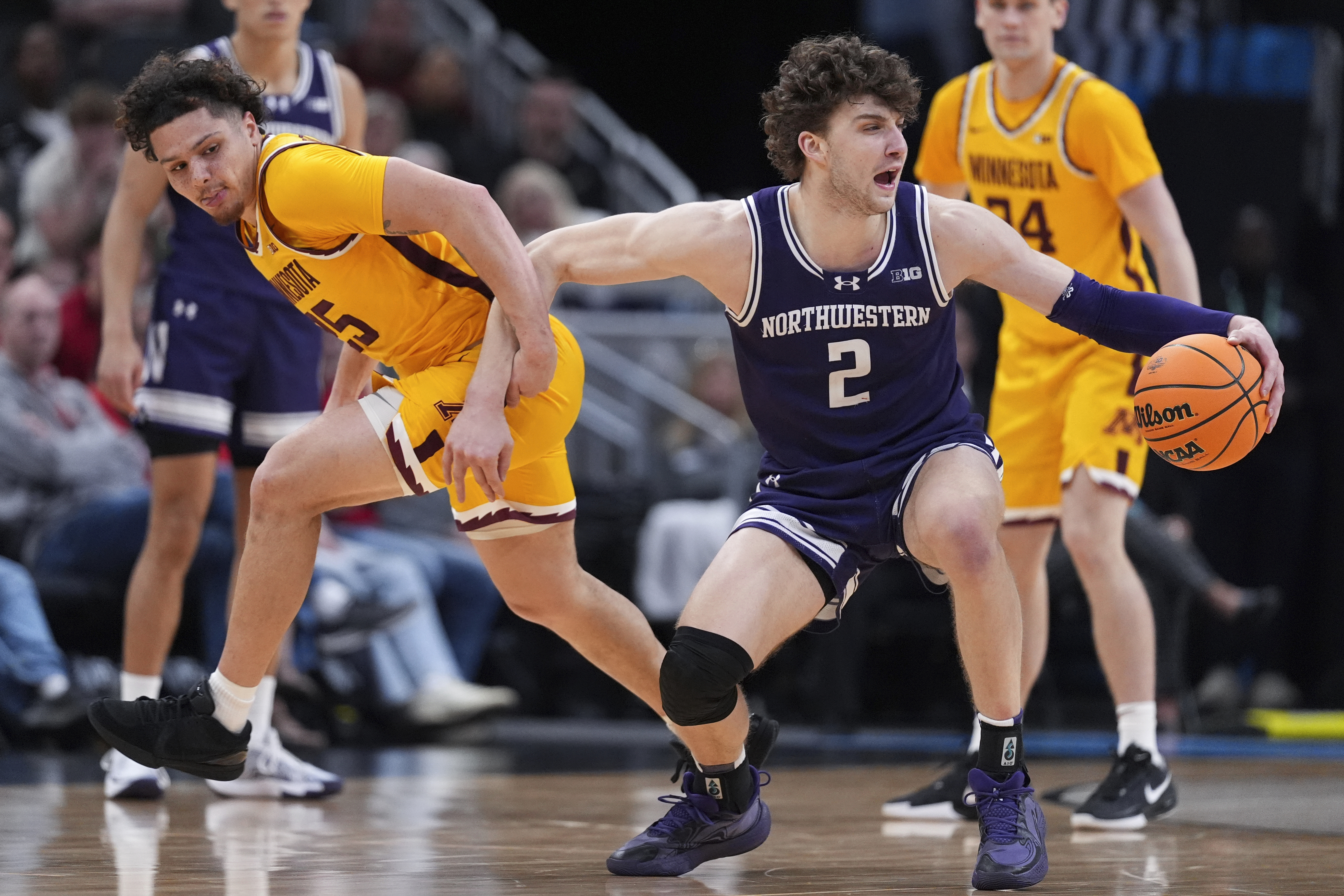 Northwestern forward Nick Martinelli (2) protects the ball from Minnesota guard Lu'Cye Patterson (25) during the second half of an NCAA college basketball game in the first round of the Big Ten Conference tournament in Indianapolis, Wednesday, March 12, 2025. 