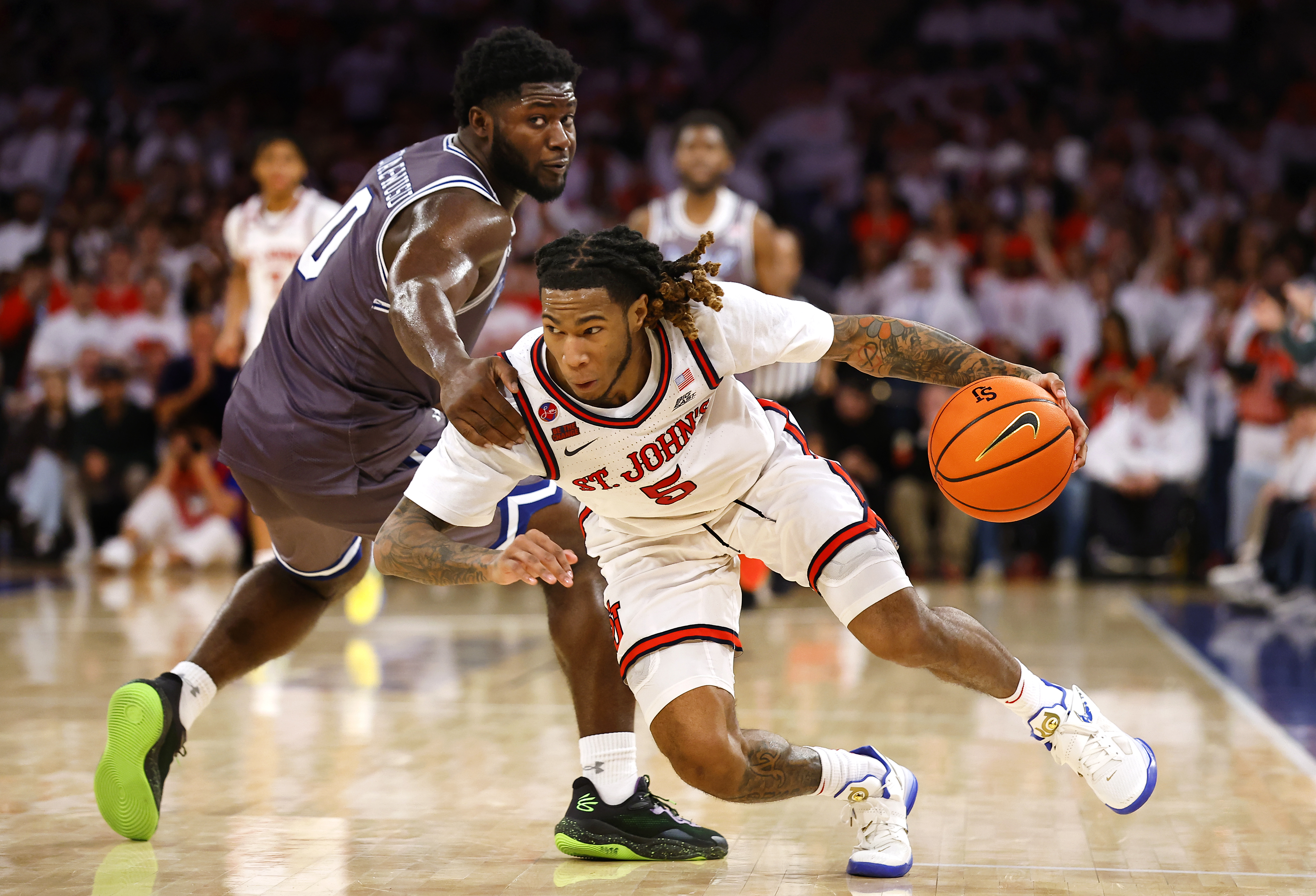 St. John's guard Deivon Smith (5) is fouled by Seton Hall guard Dylan Addae-Wusu (0) during the second half of an NCAA college basketball game, Saturday, March 1, 2025, in New York.