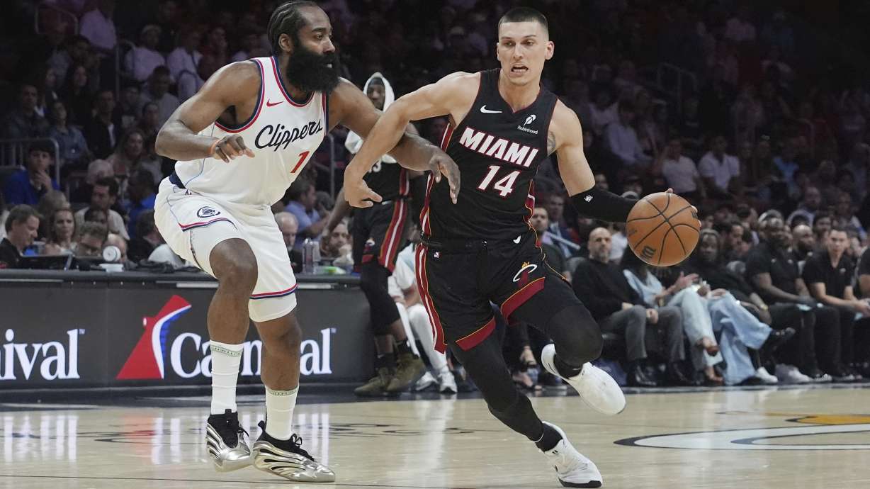 LA Clippers guard James Harden (1) defends Miami Heat guard Tyler Herro (14) during the first half of an NBA basketball game, Wednesday, March 12, 2025, in Miami.