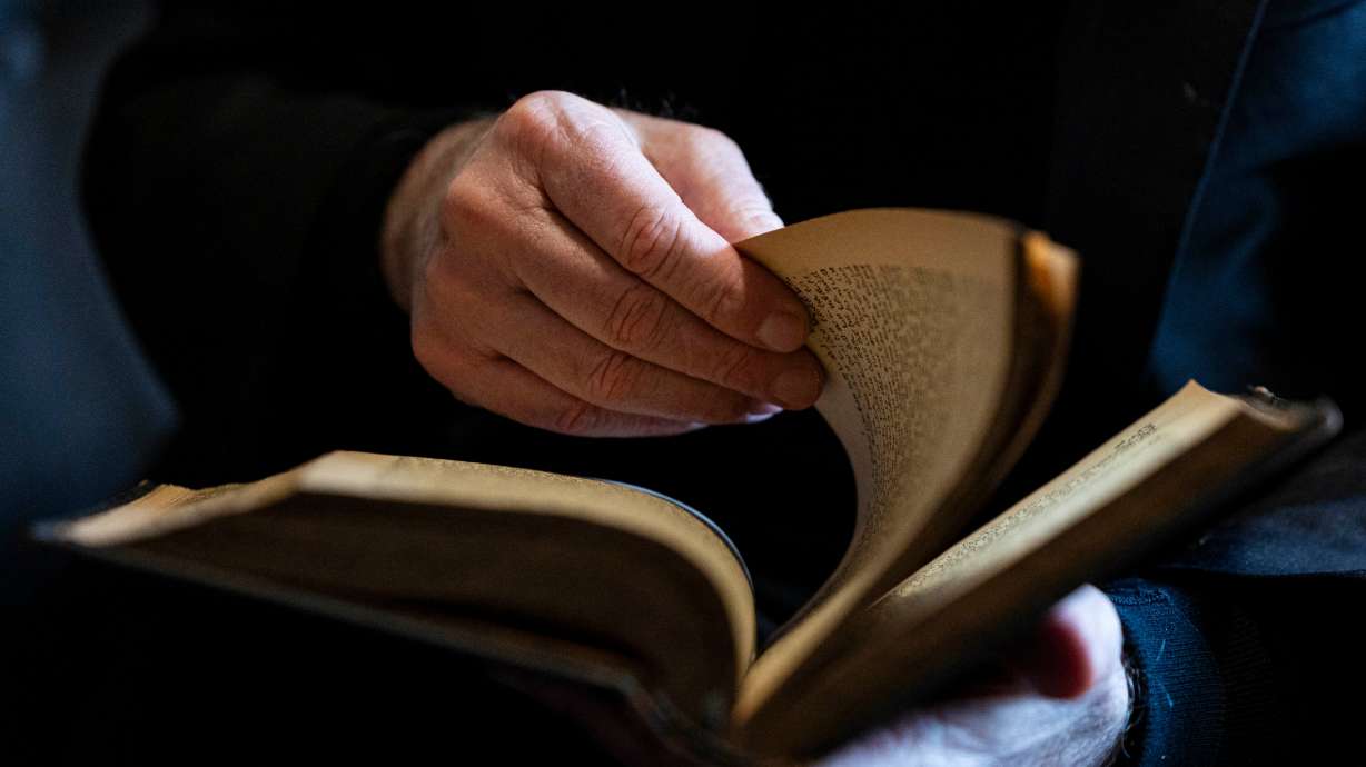 Amos Guiora flips through a book that was taken by Nazis from his Jewish grandfather during World War II, at his home in Salt Lake City on Feb. 24. It's rare that books the Nazis stole from Jews end up with their original owners.