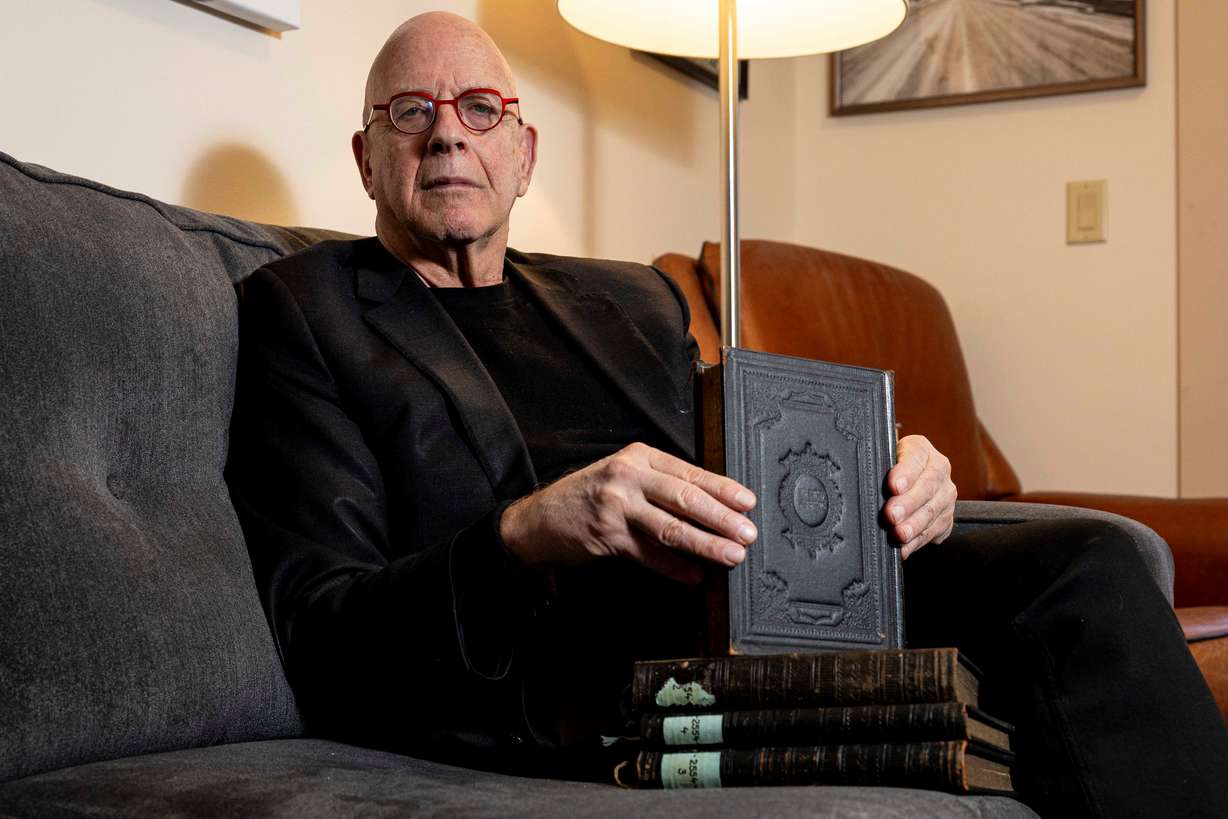 Amos Guiora poses for a portrait with books that were taken by Nazis from his Jewish grandfather during World War II at his home in Salt Lake City on Feb. 24. The books were taken from his paternal grandfather, Shlomo Natan Goldberg, when he arrived in Auschwitz, and he later died there on May 26, 1944. The books were recently returned to Guiora by an organization in Germany.