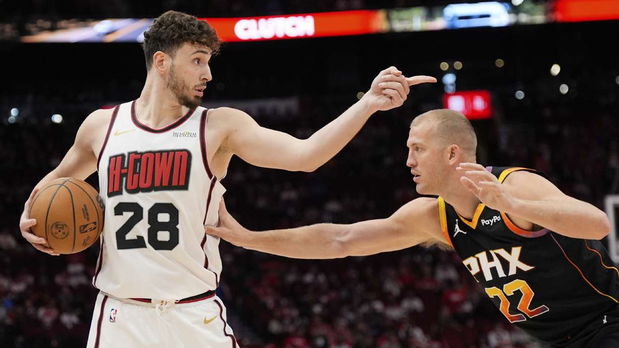 Houston Rockets' Alperen Sengun (28) points over Phoenix Suns' Mason Plumlee (22) during the first half of an NBA basketball game Wednesday, March 12, 2025, in Houston.