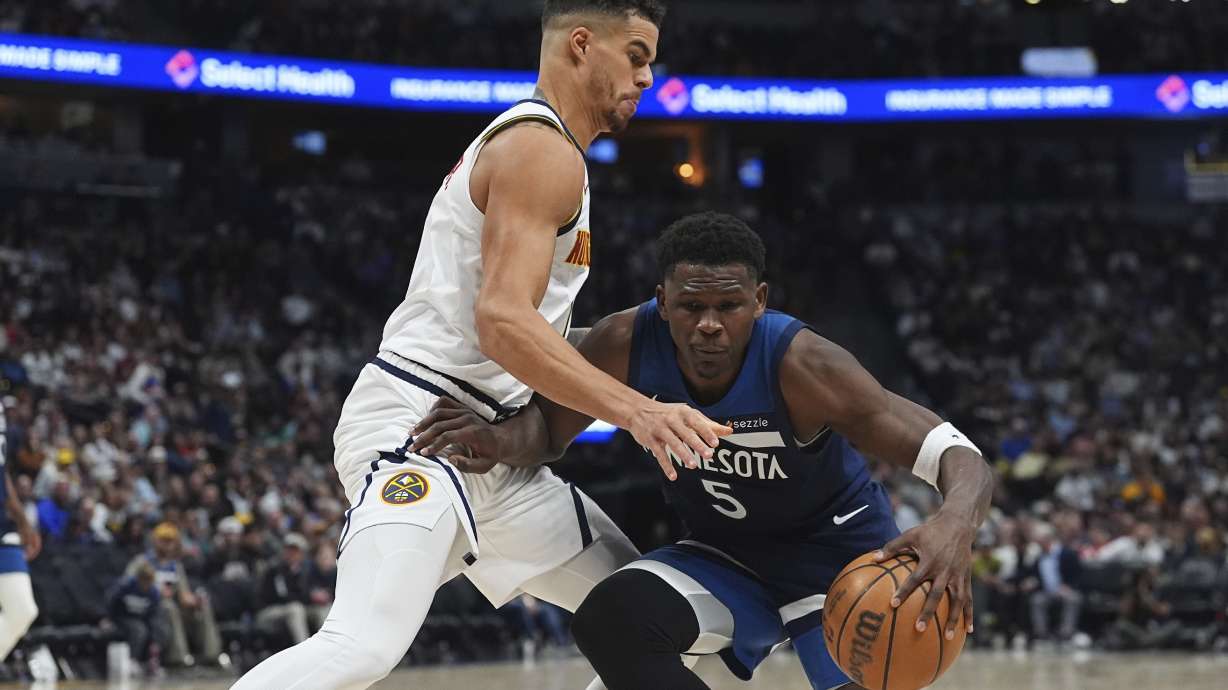 Minnesota Timberwolves guard Anthony Edwards, right, drives the lane as Denver Nuggets forward Michael Porter Jr. defends in the second half of an NBA basketball game Wednesday, March 12, 2025, in Denver.