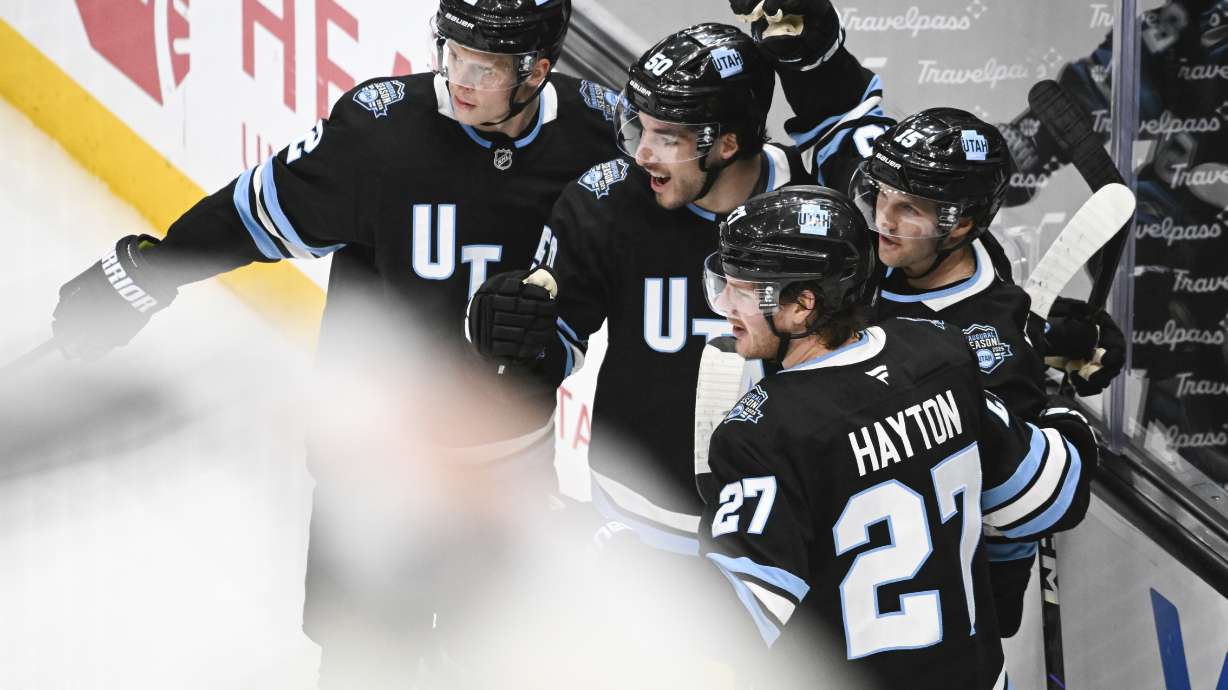 Utah Hockey Club center Alexander Kerfoot, right, celebrates a goal with teammates Olli Määttä (2), Sean Durzi (50) and Barrett Hayton (27) during the second period of an NHL hockey game against the Anaheim Ducks, Wednesday, March 12, 2025, in Salt Lake City.