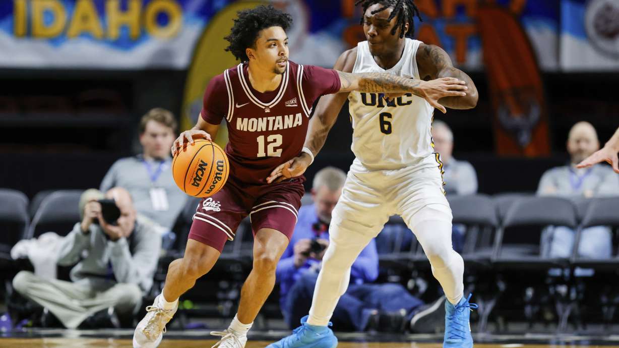 Montana guard Brandon Whitney (12) works the ball around the defense of Northern Colorado guard Langston Reynolds (6) during an NCAA college basketball game in the championship of the Big Sky tournament, Wednesday, March 12, 2025, in Boise, Idaho.