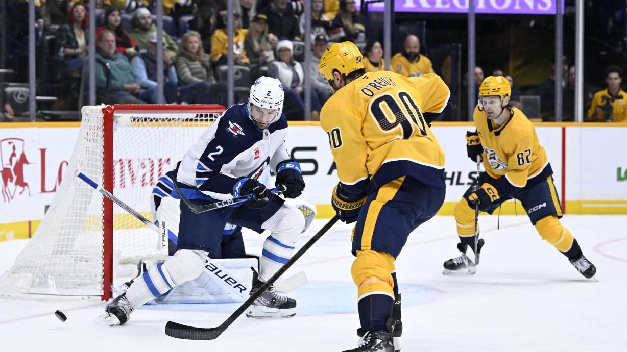 Nashville Predators center Ryan O'Reilly (90) shoots as Winnipeg Jets defenseman Dylan DeMelo (2) defends during the second period of an NHL hockey game Thursday, Feb. 27, 2025, in Nashville, Tenn.