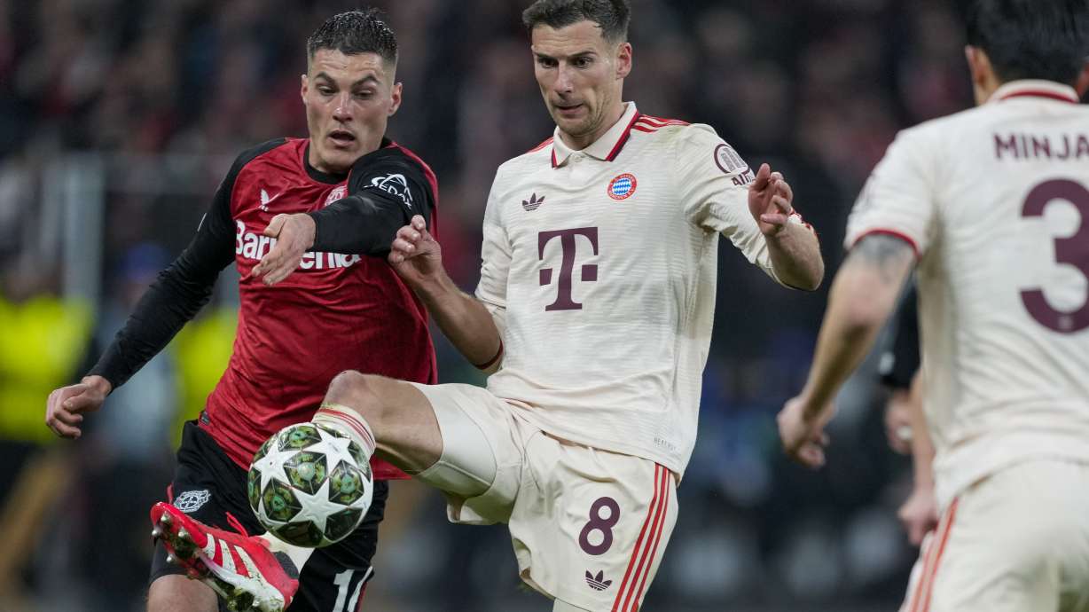 Bayern's Leon Goretzka, center, duels for the ball with Leverkusen's Patrik Schick, left, during the Champions League round of 16 second leg soccer match between Bayer Leverkusen and Bayern Munich at the BayArena in Leverkusen, Germany, Tuesday, March 11, 2025.