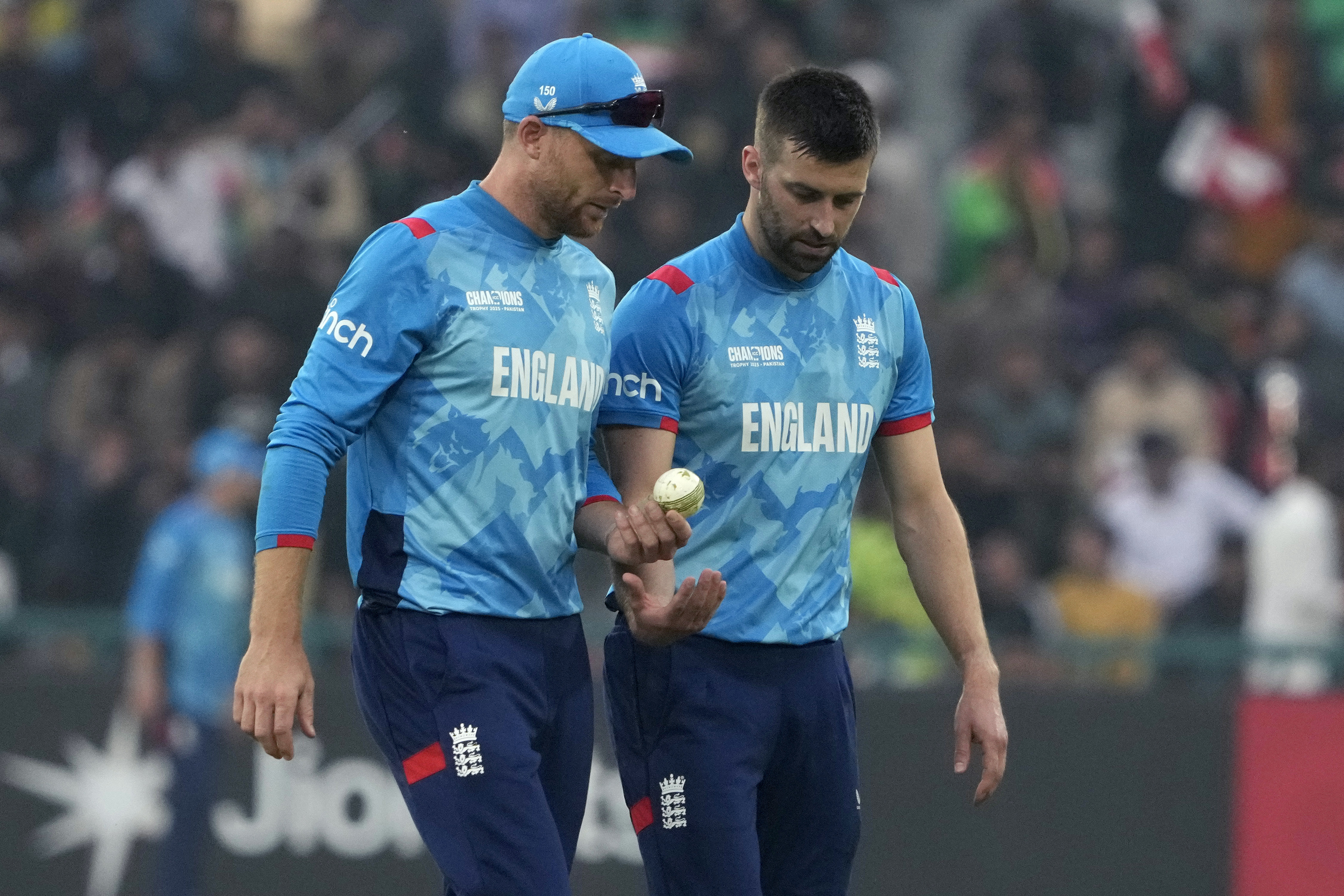 England's Mark Wood, right, chats with Jos Buttler during the ICC Champions Trophy cricket match between Afghanistan and England, in Lahore, Pakistan, Wednesday, Feb. 26, 2025.