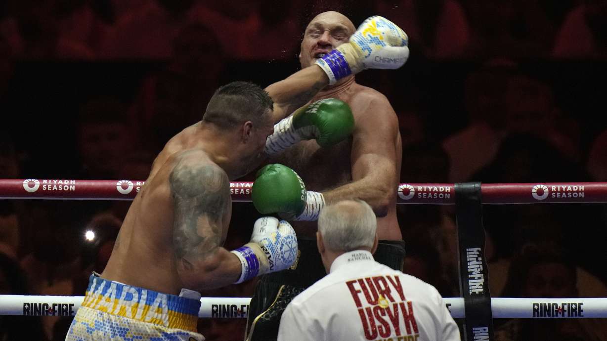 FILE - Britain's Tyson Fury, rear, takes a blow from Ukraine's Oleksandr Usyk during their undisputed heavyweight world championship boxing fight at the Kingdom Arena in Riyadh, Saudi Arabia, Sunday, May 19, 2024. The photo was part of a series of images by photographer Francisco Seco which won the Thomas V. diLustro best portfolio award for 2024 given out by the Associated Press Sports Editors during their annual winter meeting.