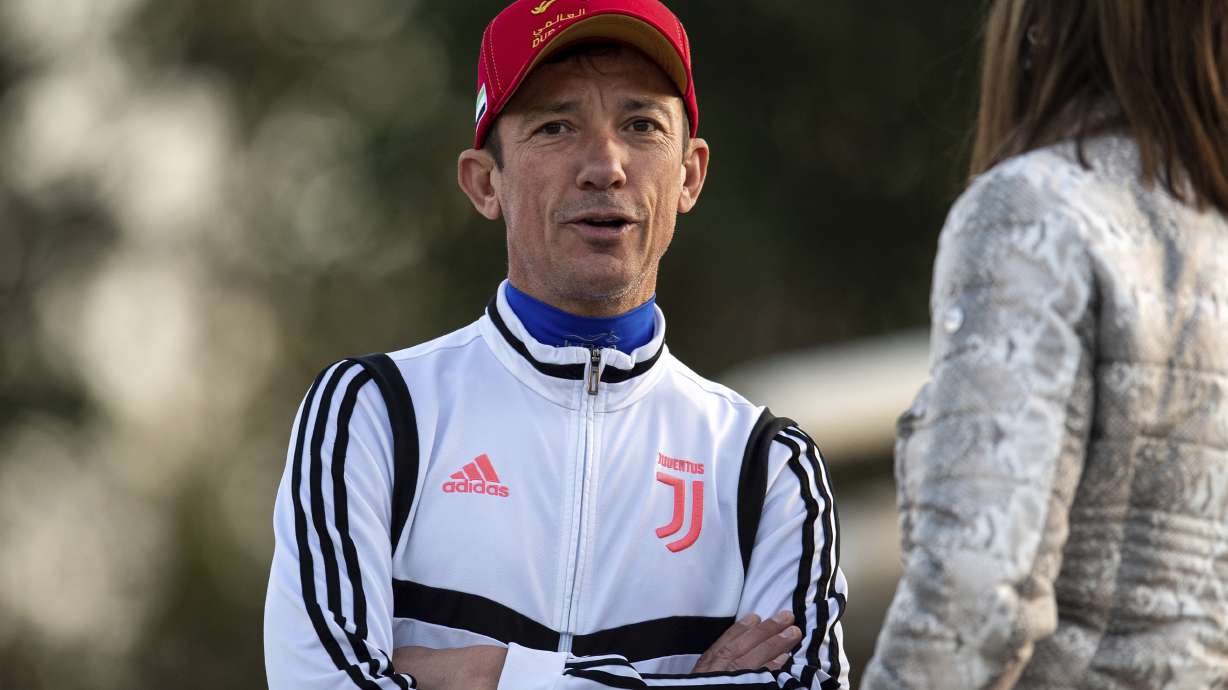 FILE - Jockey Frankie Dettori talks to horse connections during the morning track work at the Meydan racecourse training track in Dubai, United Arab Emirates, Friday, March 24, 2023.