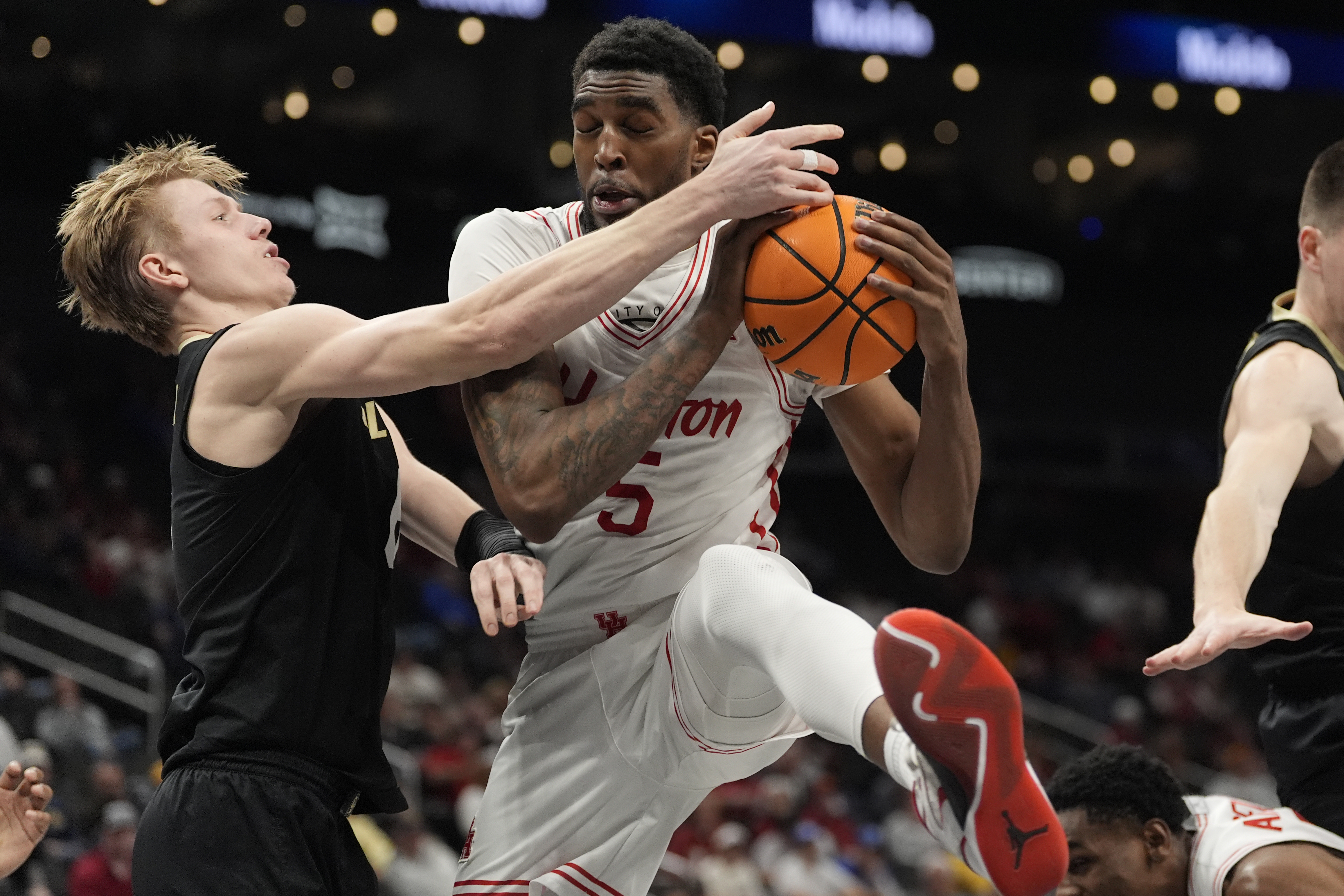 Houston's Ja'Vier Francis (5) grabs a rebound as Colorado's Trevor Baskin, left, defendsduring the first half of an NCAA college basketball game in the quarterfinal round of the Big 12 Conference tournament, Thursday, March 13, 2025, in Kansas City, Mo.