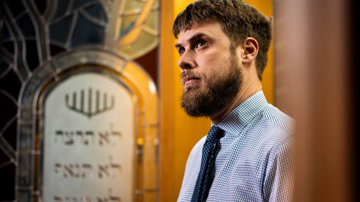 Rabbi Samuel Spector poses for a portrait inside the sanctuary with the ark, the cabinet in which the Torah scrolls are stored, standing behind him at Congregation Kol Ami in Salt Lake City on Feb. 28.