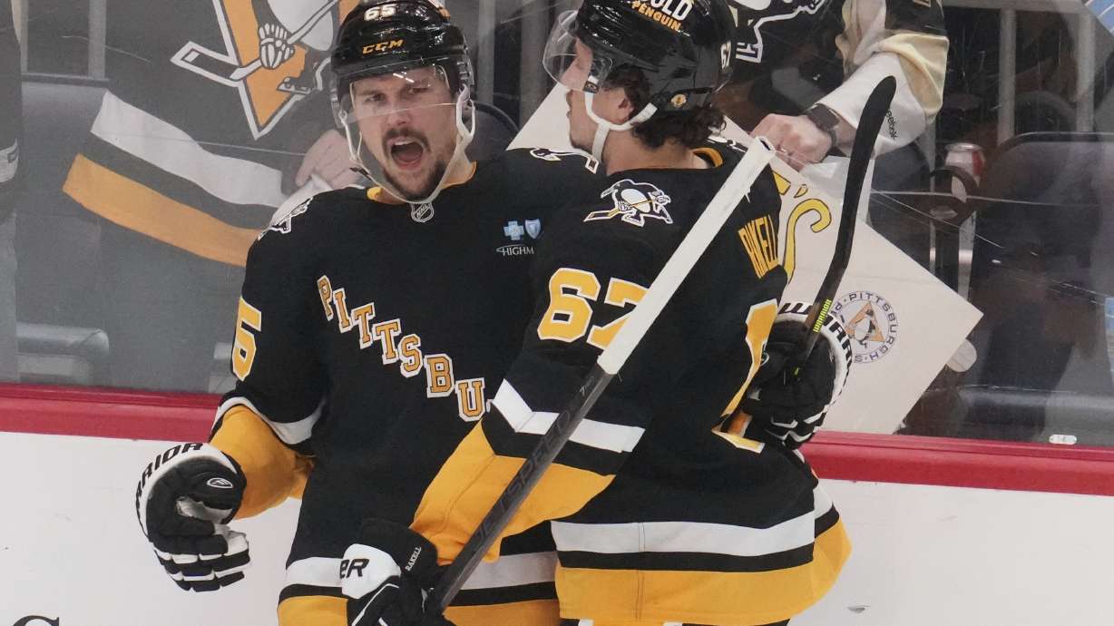 Pittsburgh Penguins' Erik Karlsson (65) celebrates with Rickard Rakell after getting the game-winning goal during the overtime period of an NHL hockey game against the Vegas Golden Knights in Pittsburgh, Tuesday, March 11, 2025.