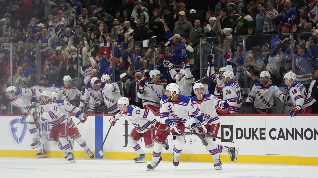 New York Rangers players celebrate after an overtime win against the Minnesota Wild in an NHL hockey game, Thursday, March 13, 2025, in St. Paul, Minn.