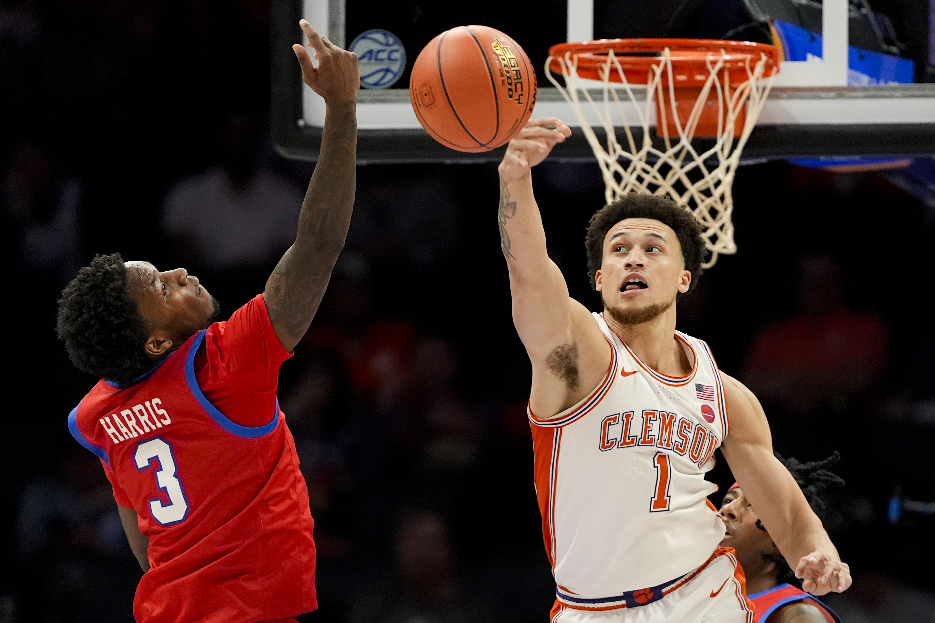 Clemson guard Chase Hunter blocks a shot by SMU guard Chuck Harris during the first half of an NCAA college basketball game in the quarterfinals of the Atlantic Coast Conference tournament, Thursday, March 13, 2025, in Charlotte, N.C.