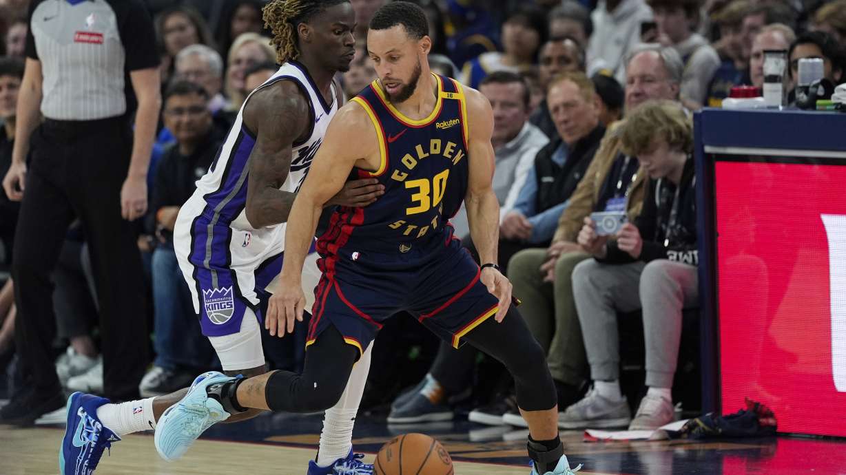 Golden State Warriors guard Stephen Curry (30) moves the ball while defended by Sacramento Kings guard Keon Ellis during the first half of an NBA basketball game Thursday, March 13, 2025, in San Francisco.