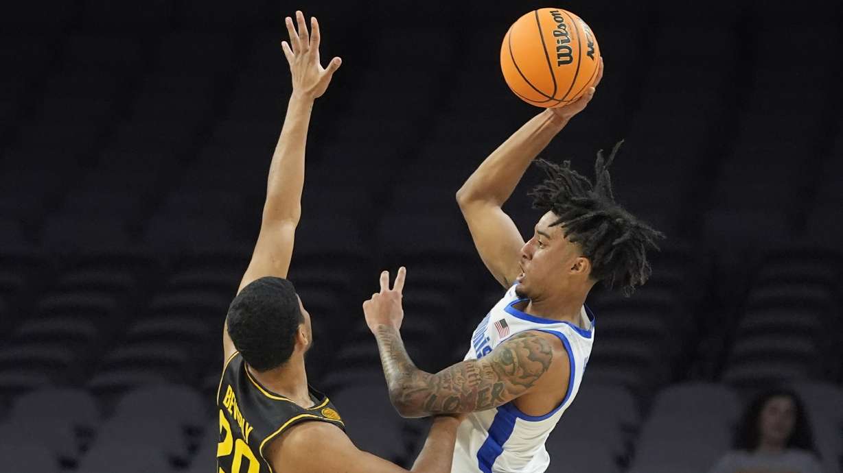 Memphis guard PJ Haggerty, right, shoots against Wichita State guard Harlond Beverly (20) during the first half of an NCAA college basketball game in the quarterfinals of the American Athletic Conference tournament in Fort Worth, Texas, Friday, March 14, 2025.