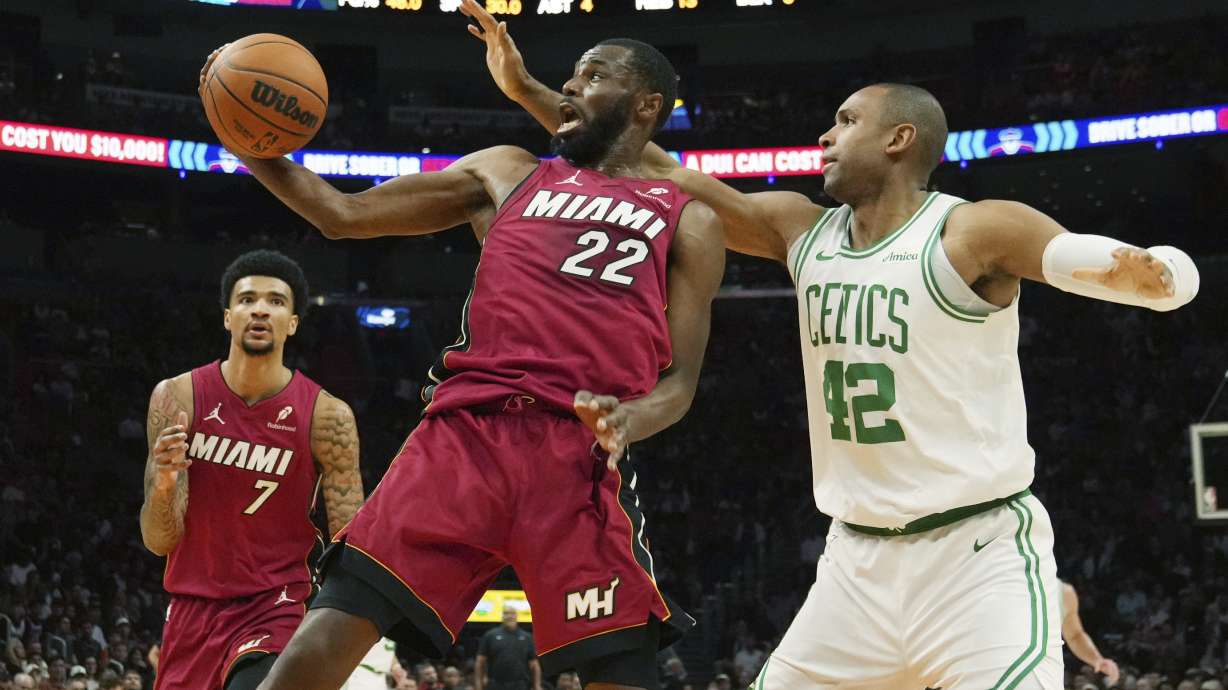 Miami Heat forward Andrew Wiggins (22) and Boston Celtics center Al Horford (42) go after a rebound during the first half of an NBA basketball game, Friday, March 14, 2025, in Miami.