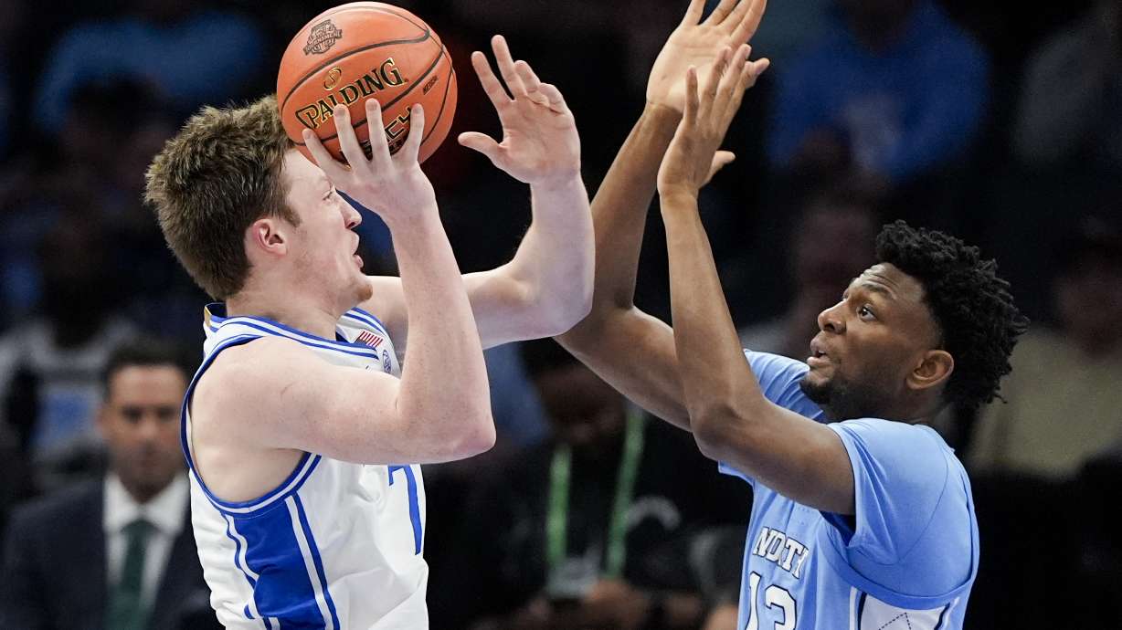 Duke guard Kon Knueppel shoots over North Carolina forward Jalen Washington during the first half of an NCAA college basketball game in the semifinals of the Atlantic Coast Conference tournament, Friday, March 14, 2025, in Charlotte, N.C.