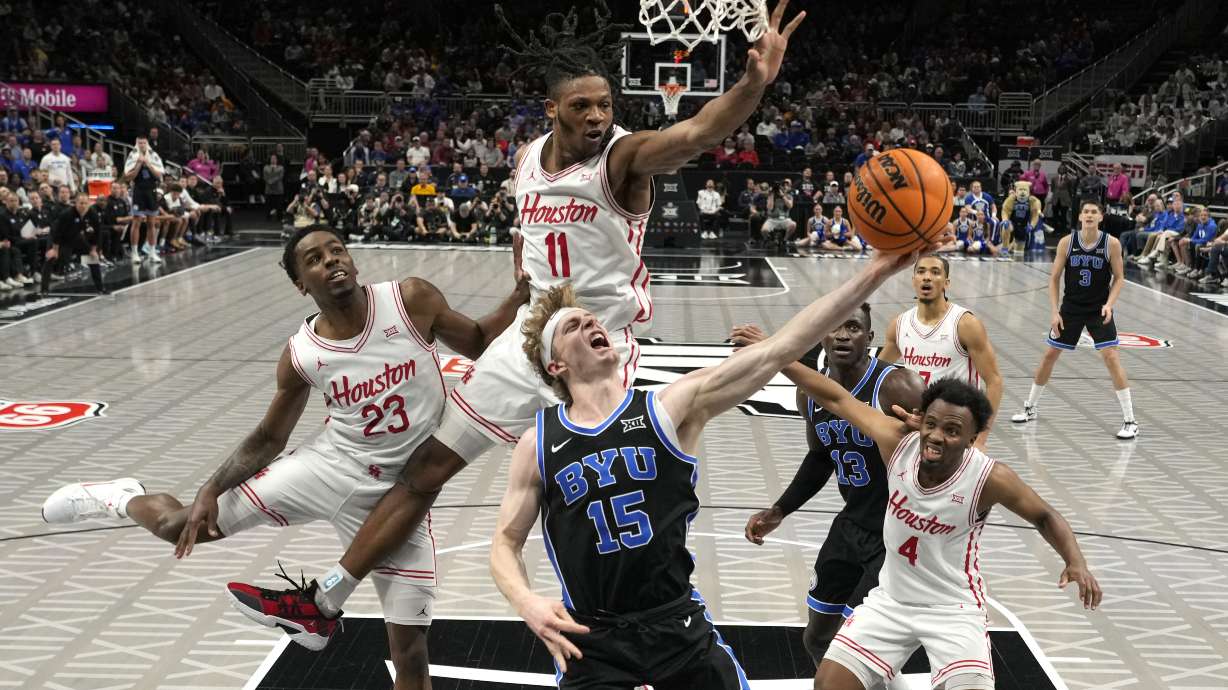 Brigham Young's Richie Saunders (15) shoots as Houston's Terrance Arceneaux (23), Joseph Tugler (11) and L.J. Cryer (4) defend during the first half of an NCAA college basketball game in the semifinal round of the Big 12 Conference tournament, Friday, March 14, 2025, in Kansas City, Mo.