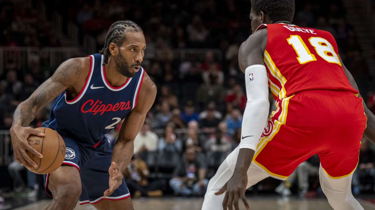 Los Angeles Clippers forward Kawhi Leonard (2), left, moves the ball against Atlanta Hawks forward Mouhamed Gueye (18), right, during the first half of an NBA basketball game, Friday, March 14, 2025, in Atlanta.
