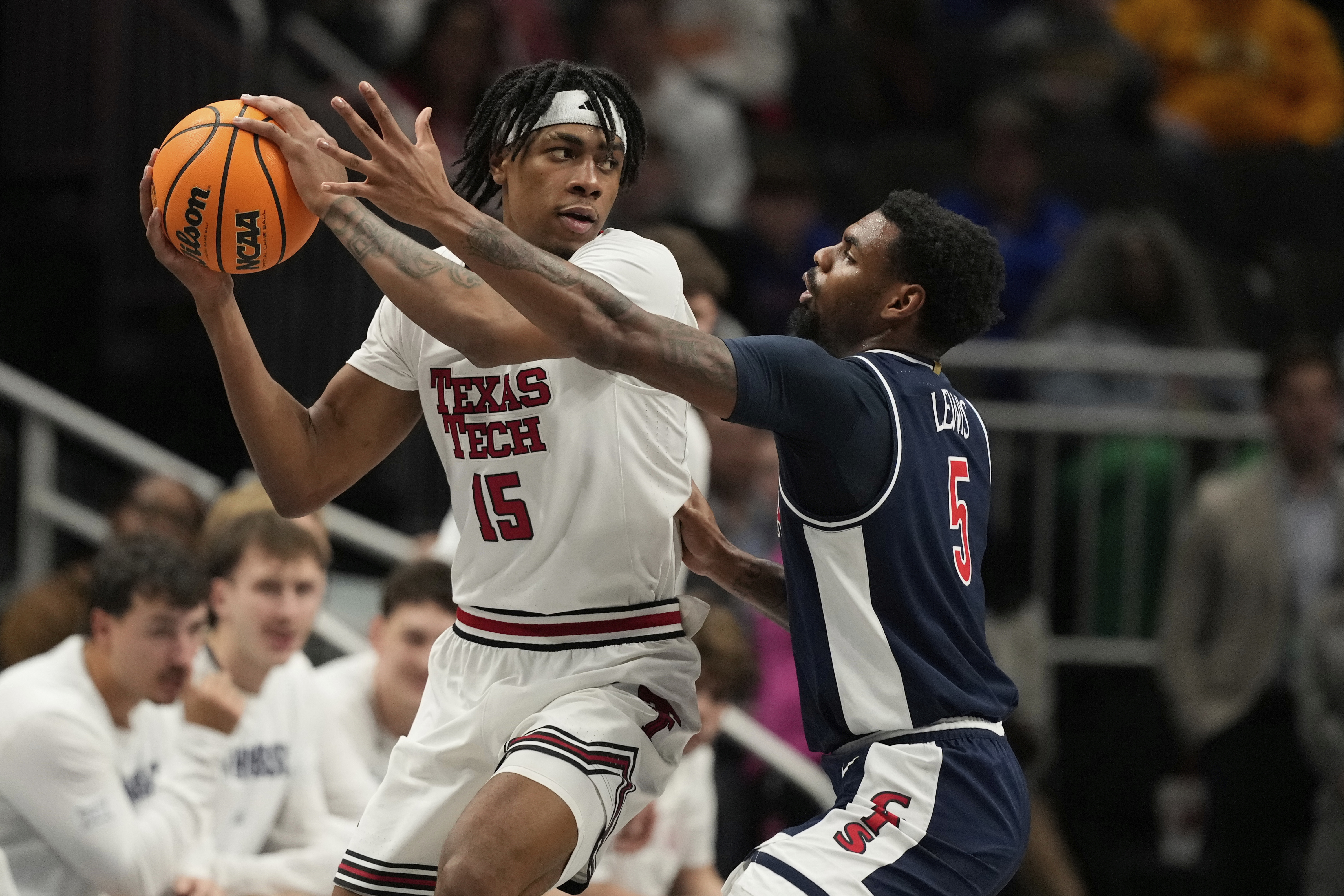Texas Tech's JT Toppin (15) looks to pass as Arizona's KJ Lewis (5) defends during the first half of an NCAA college basketball game in the semifinal round of the Big 12 Conference tournament, Friday, March 14, 2025, in Kansas City, Mo.