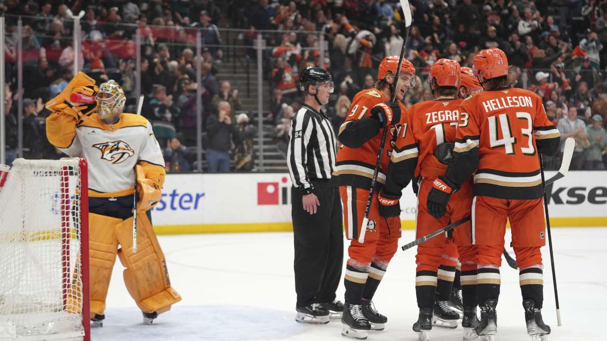 Anaheim Ducks players celebrate a goal by Alex Killorn in front of Nashville Predators goaltender Juuse Saros during the third period of an NHL hockey game Friday, March 14, 2025, in Anaheim, Calif.