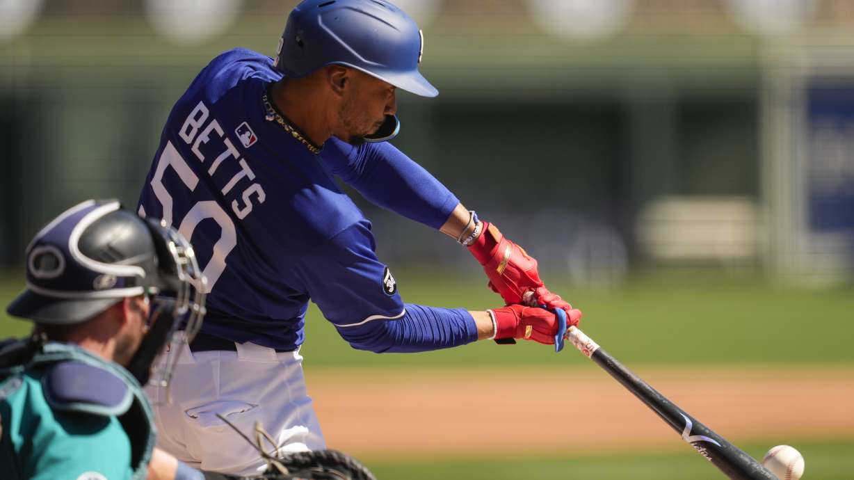 Los Angeles Dodgers' Mookie Betts singles during the first inning during a spring training baseball game against the Seattle Mariners, Tuesday, Feb. 25, 2025, in Phoenix.