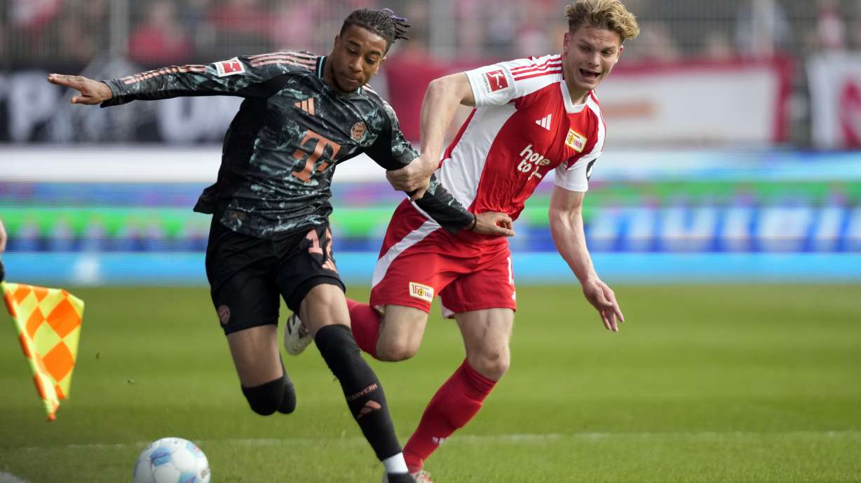 Bayern's Michael Olise, left, fights for the ball with Union's Andras Schaefer during the Bundesliga soccer match between Bayern Munich and Union Berlin at the An der Alten Forsterei stadium in Berlin, Germany, Saturday, March 15, 2025.