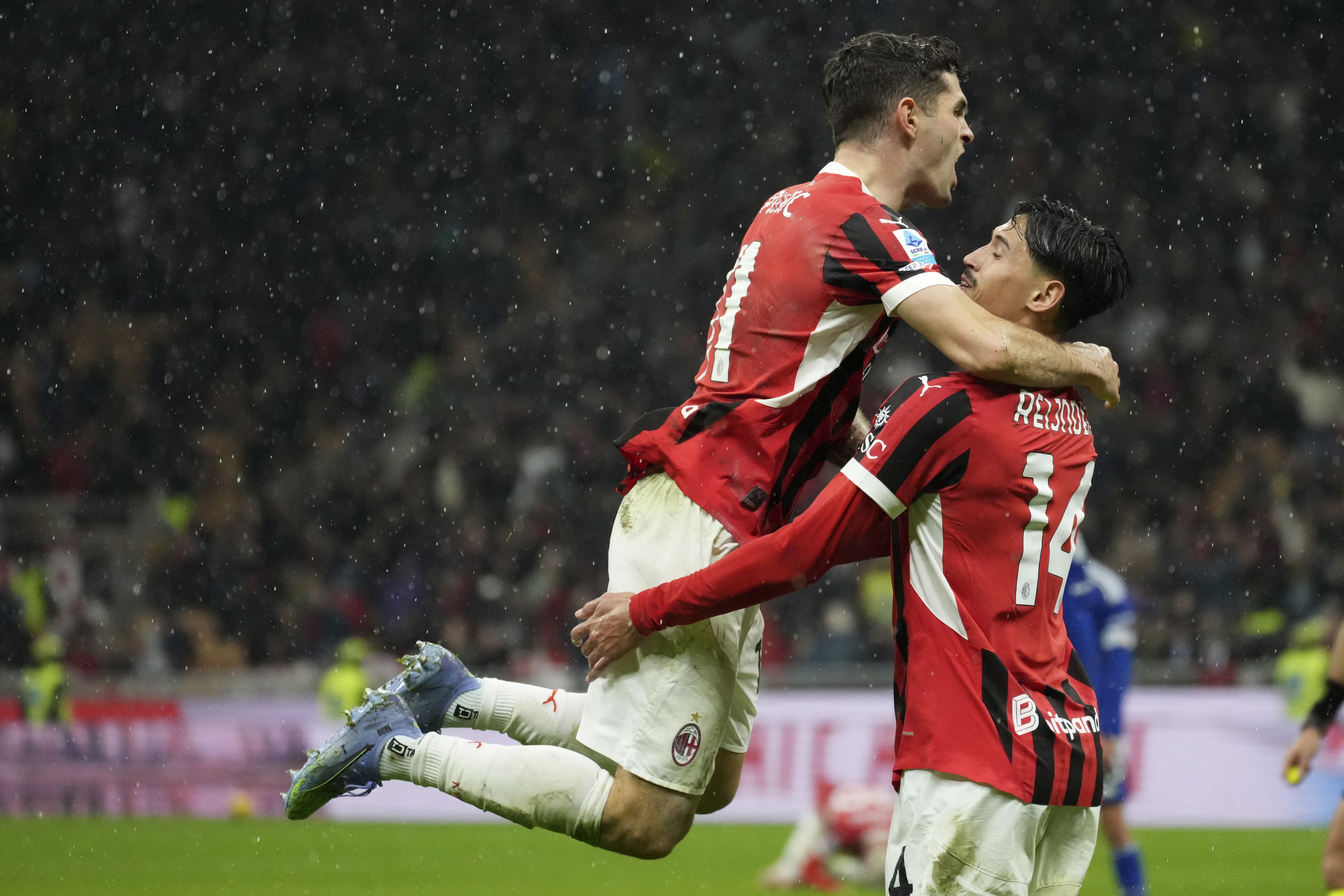 AC Milan's Tijjani Reijnders, right, with teammate Christian Pulisic, celebrates after scoring his side's second goal during the Italian Serie A soccer match between AC Milan and Como at the San Siro Stadium in Milan, Italy, Saturday, March 15, 2025.