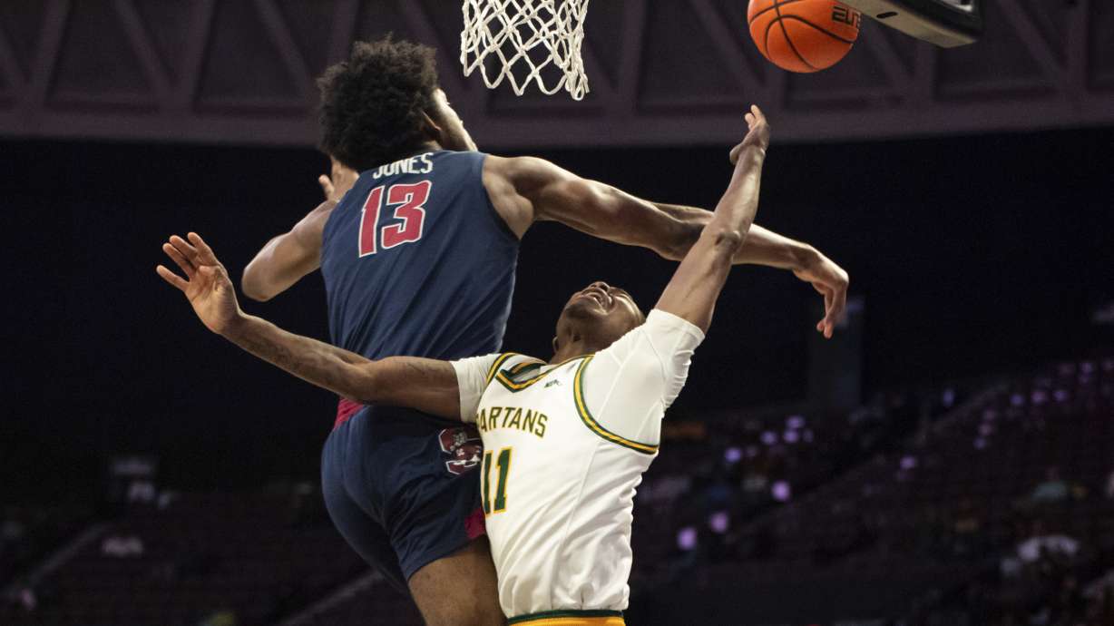 South Carolina State forward Drayton Jones (13) blocks a shot from Norfolk State guard Jaylani Darden (11) during the first half of an NCAA college basketball game in the championship of the Mid-Eastern Athletic Conference Tournament, Saturday, March 15, 2025, in Norfolk, Va.