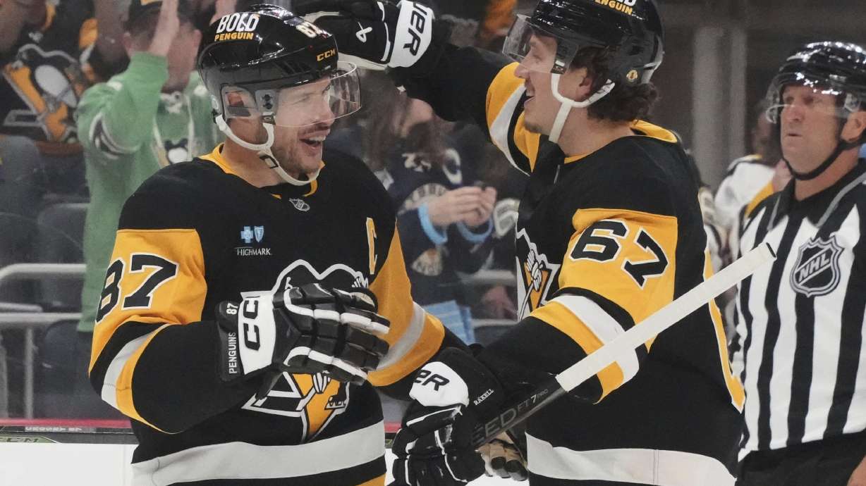 Pittsburgh Penguins' Rickard Rakell (67) celebrates with Sidney Crosby after scoring during the second period of an NHL hockey game against the New Jersey Devils in Pittsburgh, Saturday, March 15, 2025.