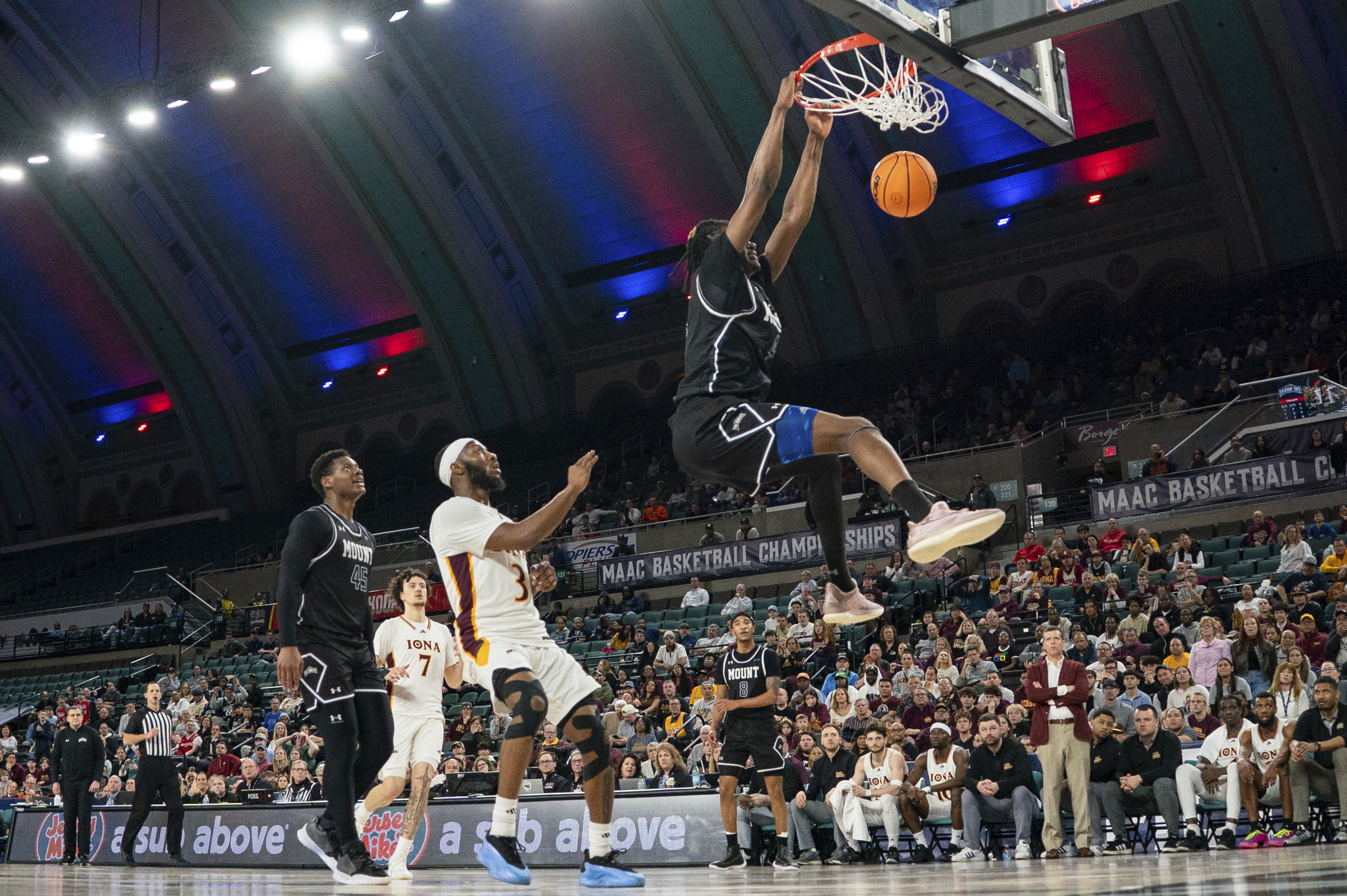Mount St. Mary's Dola Adebayo, right, dunks the ball as Iona's Dejour Reaves, center, looks on during the first half of an NCAA college basketball game in the championship of the Metro Atlantic Athletic Conference tournament, Saturday, March 15, 2025, in Atlantic City, N.J.