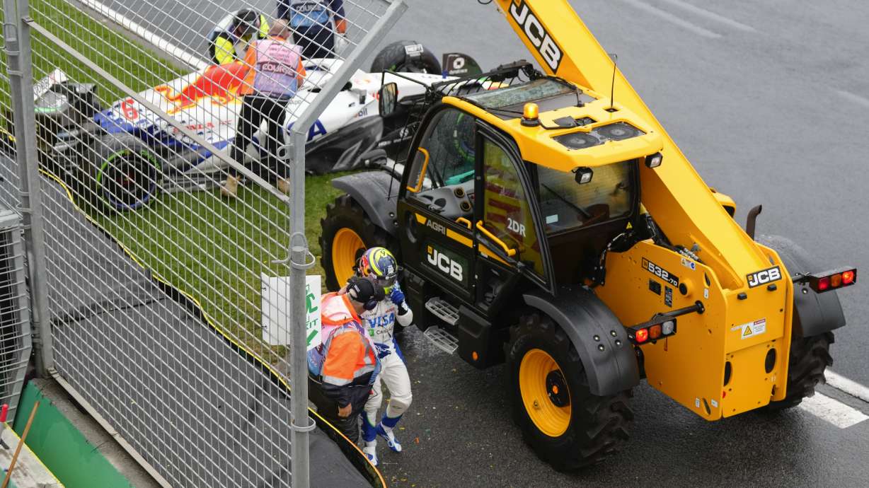 Team RB driver Isack Hadjar of France is assisted by a track marshal after his car hit a wall on the formation lap ahead of the Australian Formula One Grand Prix at Albert Park, in Melbourne, Australia, Sunday, March 16, 2025.