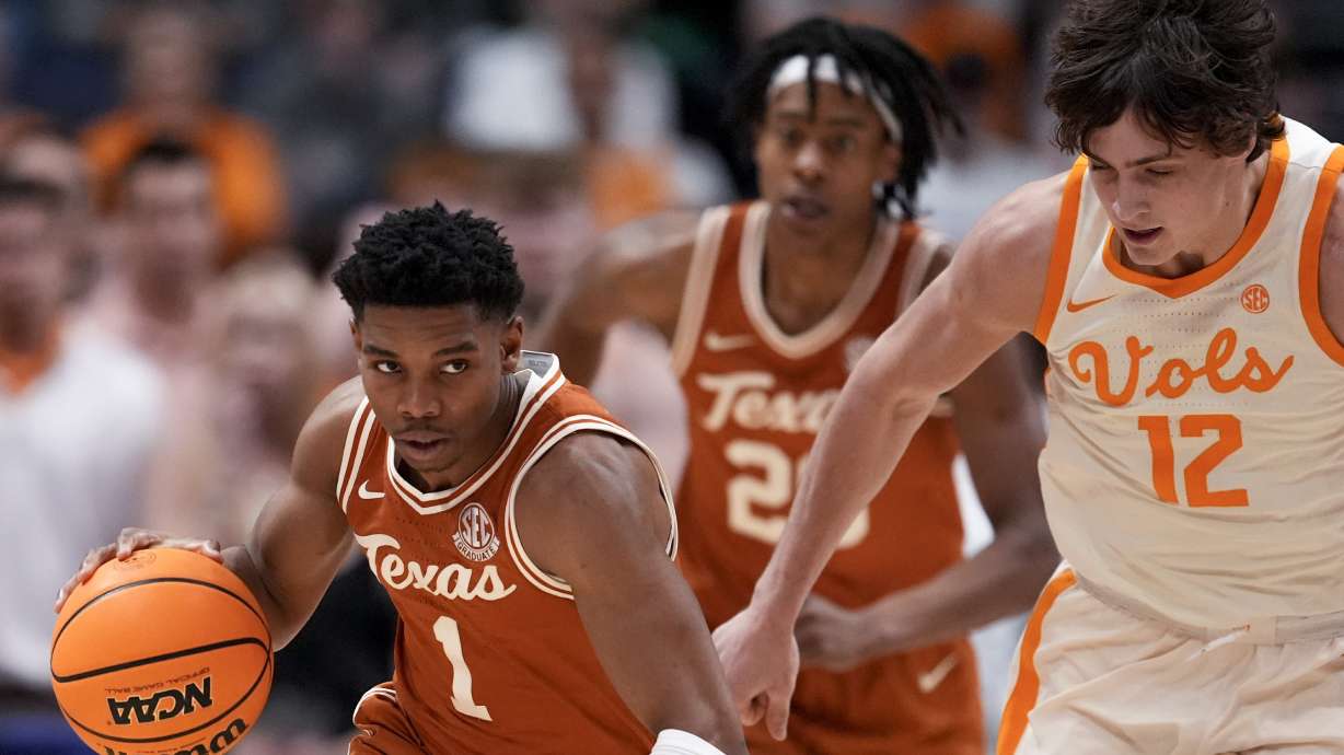Texas guard Julian Larry (1) moves against Tennessee forward Cade Phillips (12) during the second half of an NCAA college basketball game in the quarterfinal round of the Southeastern Conference tournament, Friday, March 14, 2025, in Nashville, Tenn.