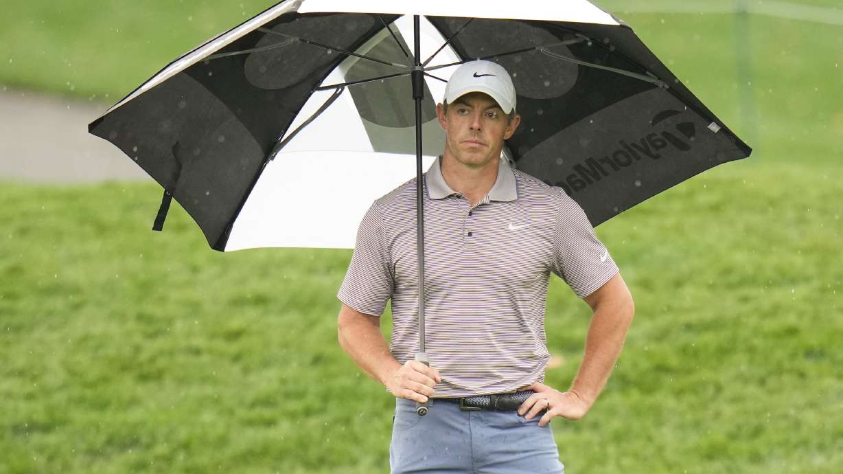 Rory McIlroy, of Northern Ireland, holds an umbrella on the 11th green during the final round of The Players Championship golf tournament Sunday, March 16, 2025, in Ponte Vedra Beach, Fla.