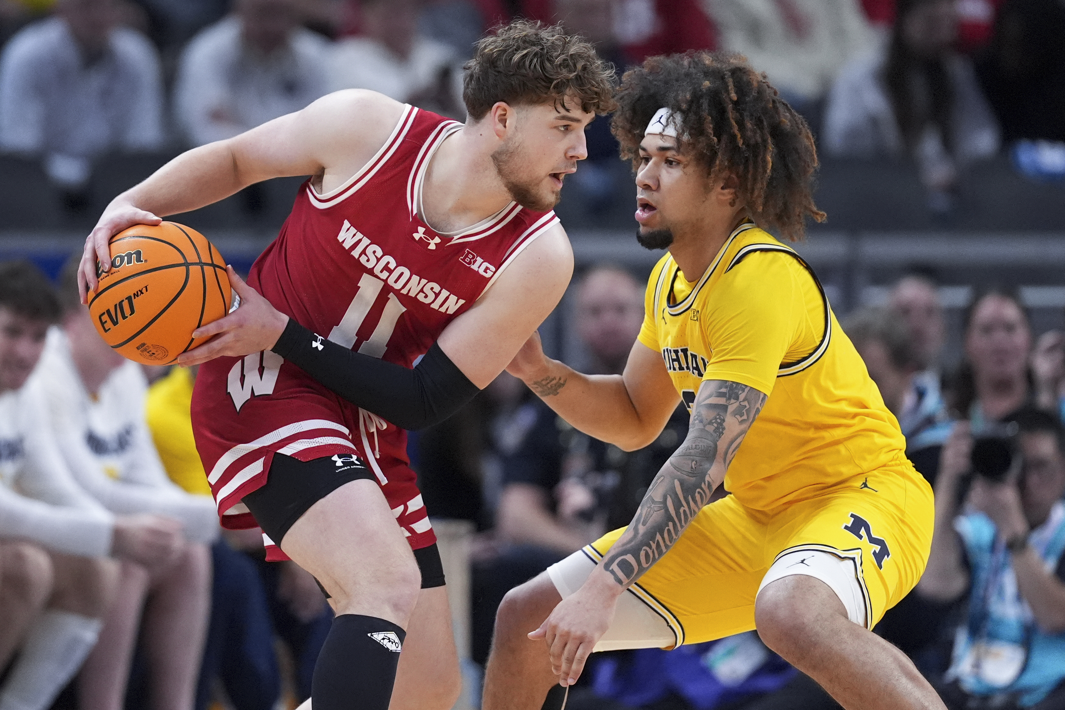 Wisconsin guard Max Klesmit (11) looks to drive on Michigan guard Tre Donaldson (3) during the first half of an NCAA college basketball game in the championship of the Big Ten Conference tournament in Indianapolis, Sunday, March 16, 2025.