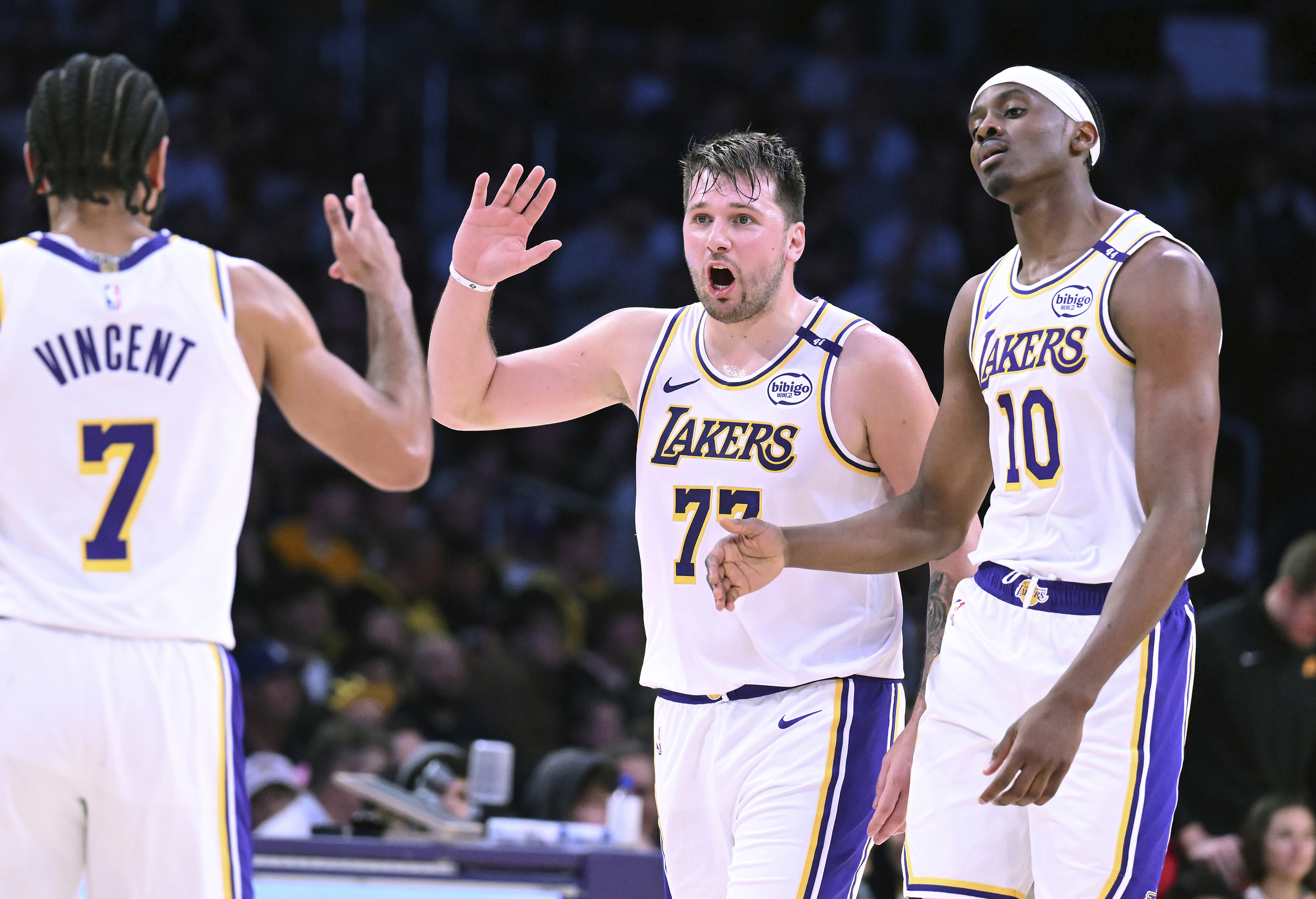 Los Angeles Lakers guard Luka Doncic (77) celebrates with guard Gabe Vincent (7) and center Christian Koloko (10) after a three-point basket against the Phoenix Suns during the first half of an NBA basketball game Sunday, March 16, 2025, in Los Angeles.